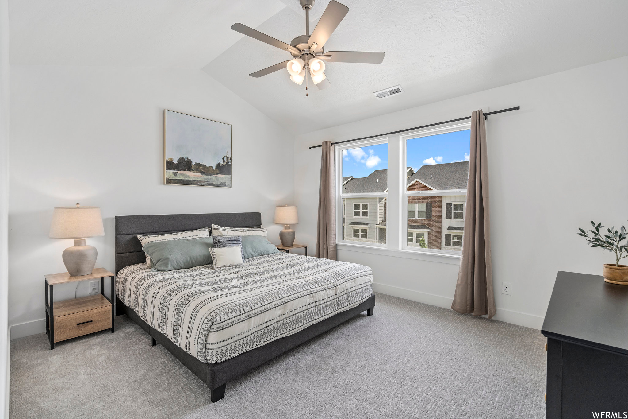 Carpeted bedroom with ceiling fan and lofted ceiling