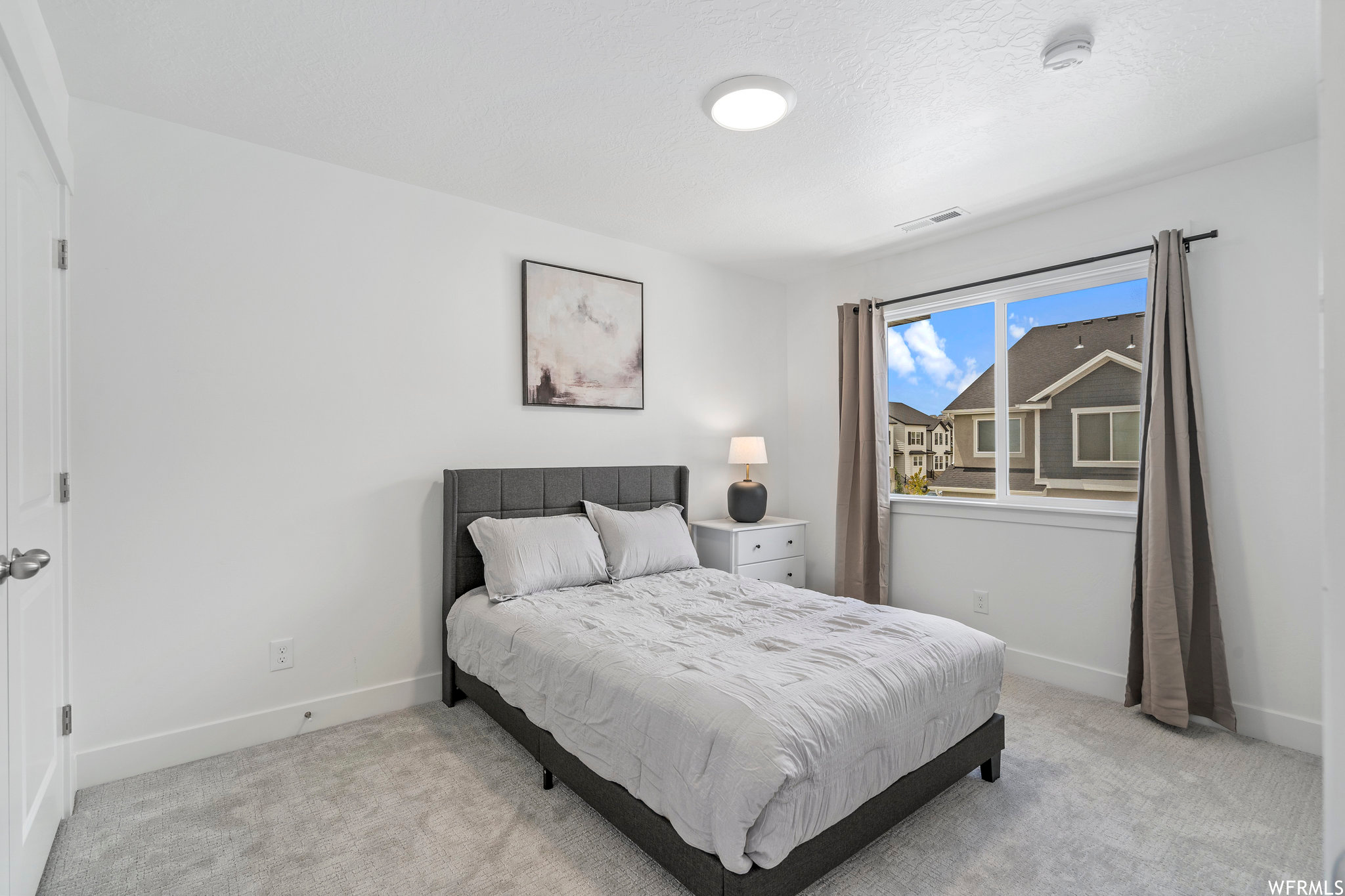 Bedroom with light colored carpet