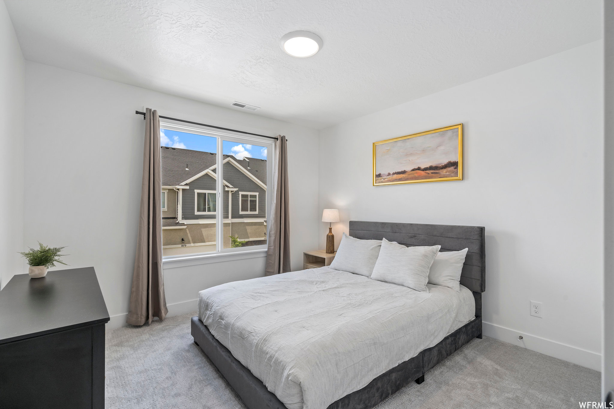 Bedroom with multiple windows and light carpet