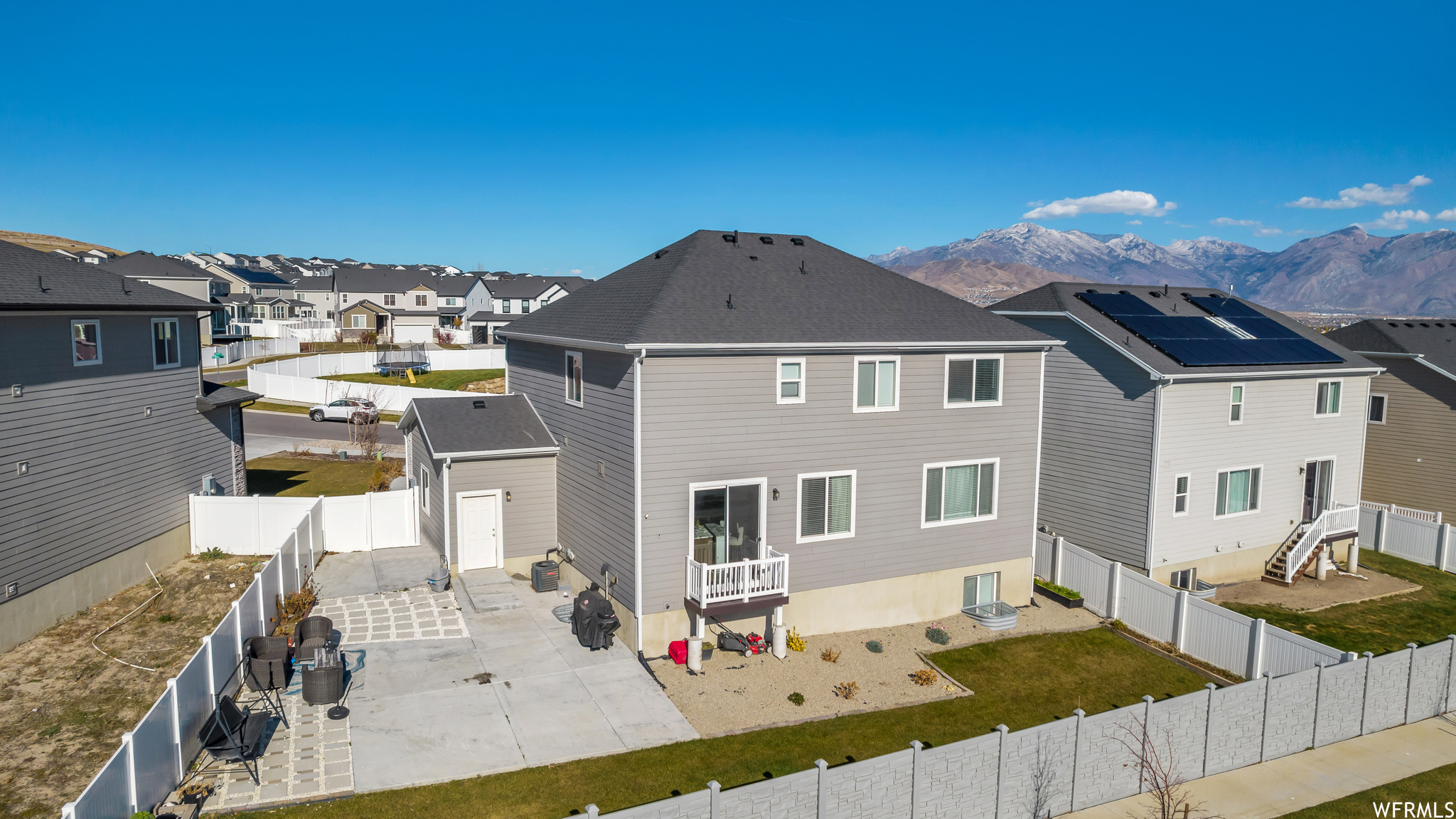 View of front of house with solar panels, a patio, and a mountain view