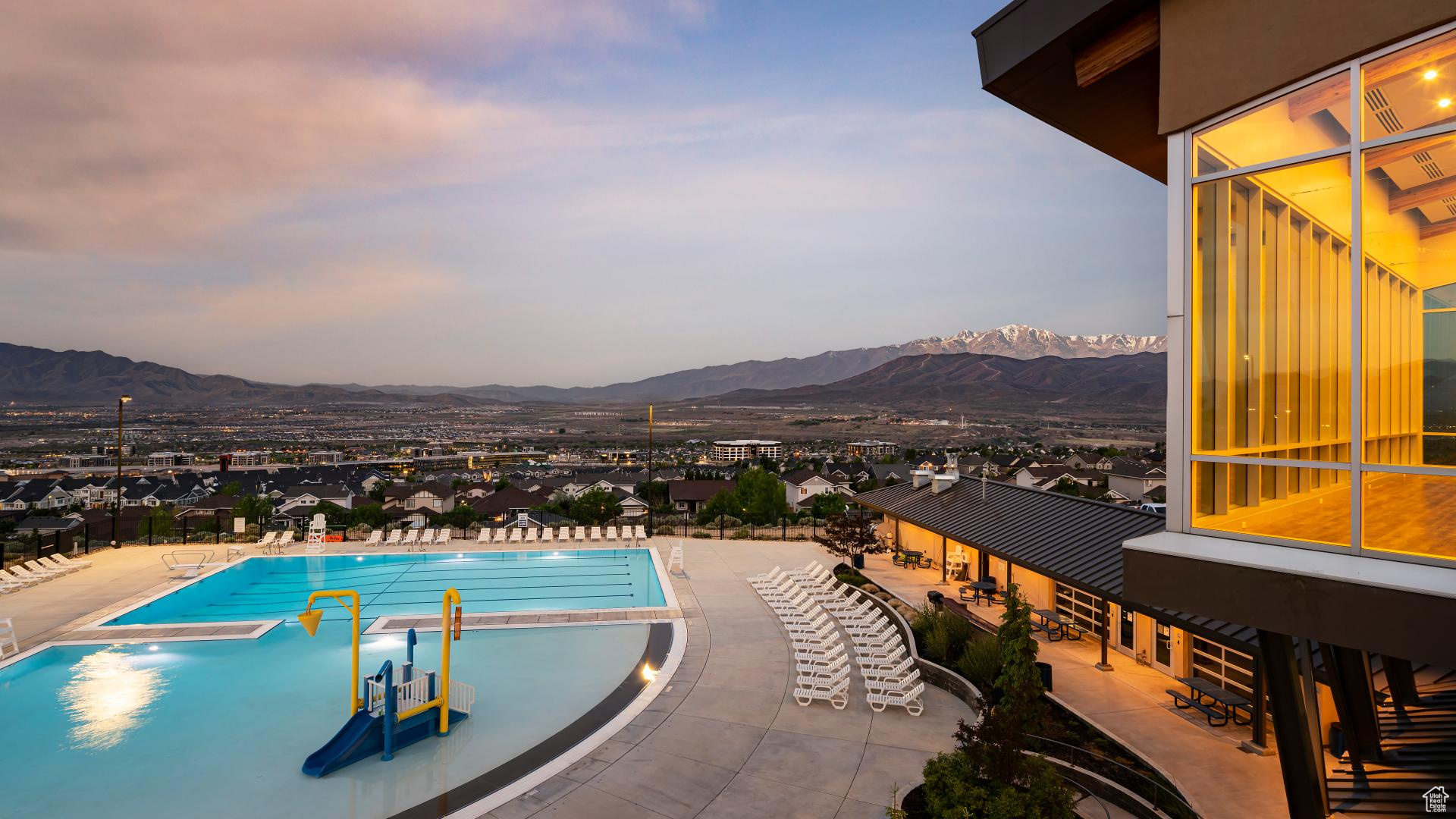 Pool at dusk with a mountain view and a patio