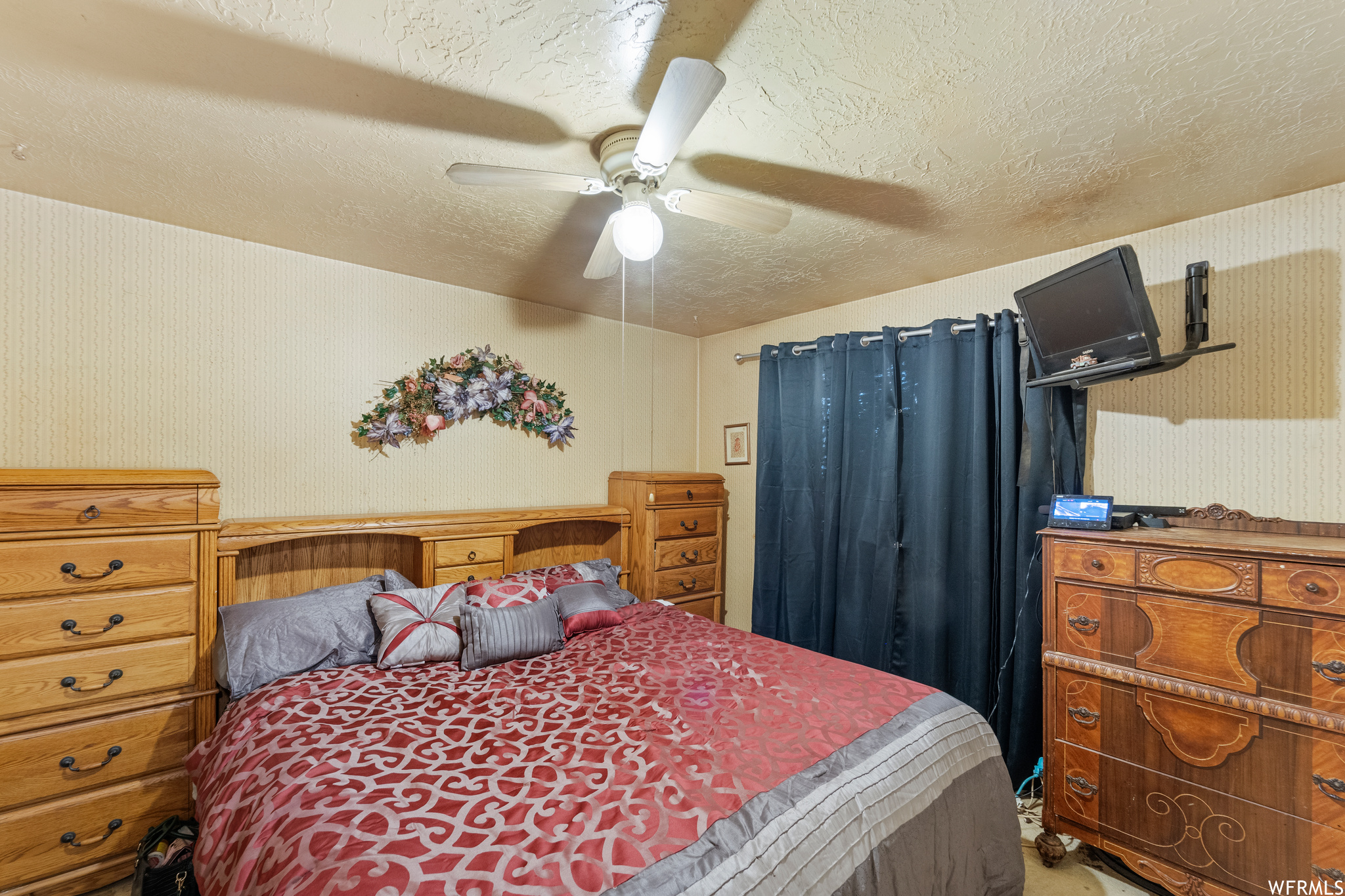 Bedroom with ceiling fan and a textured ceiling