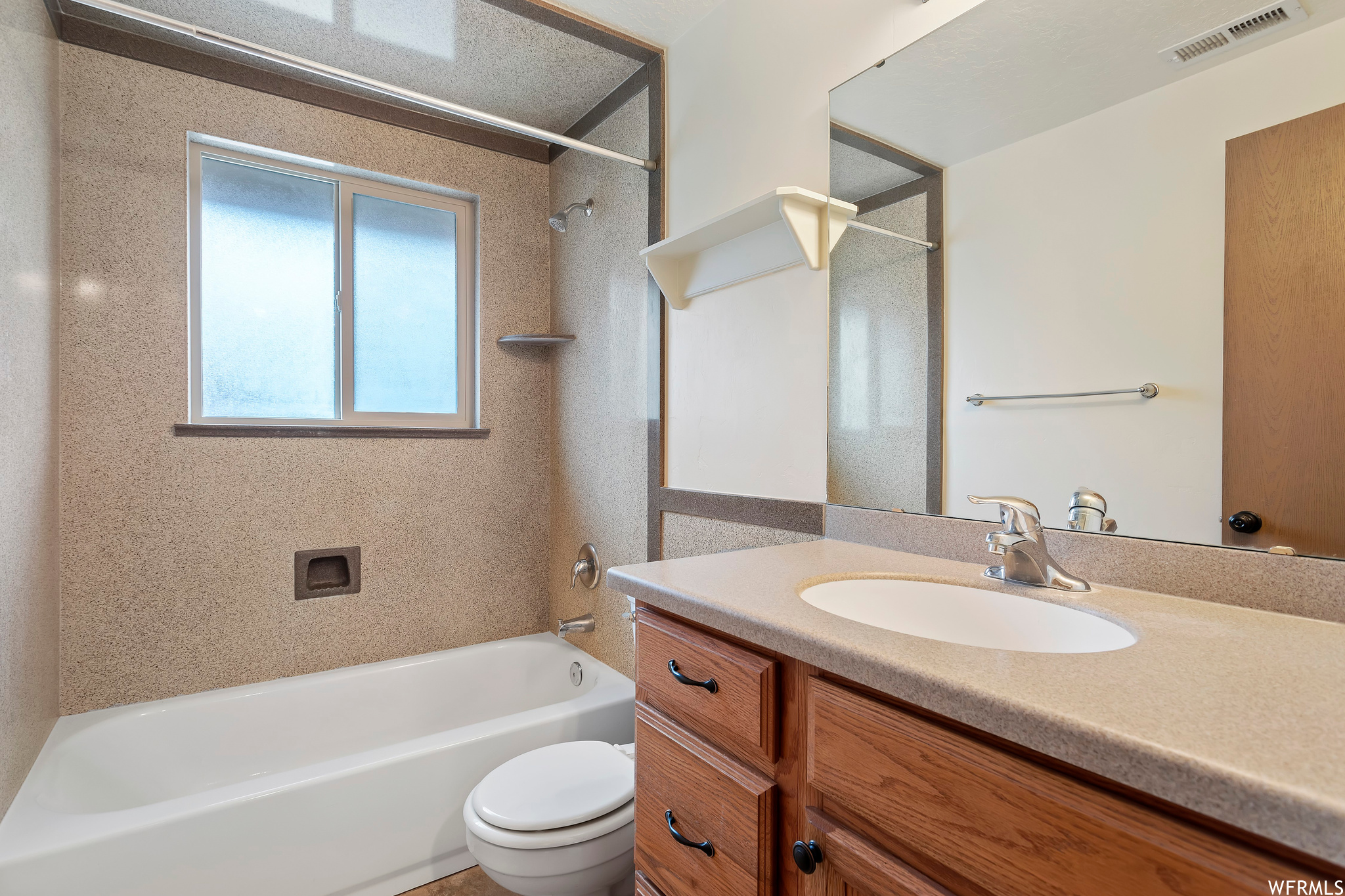 Full bathroom with toilet, bathing tub / shower combination, and vanity with extensive cabinet space