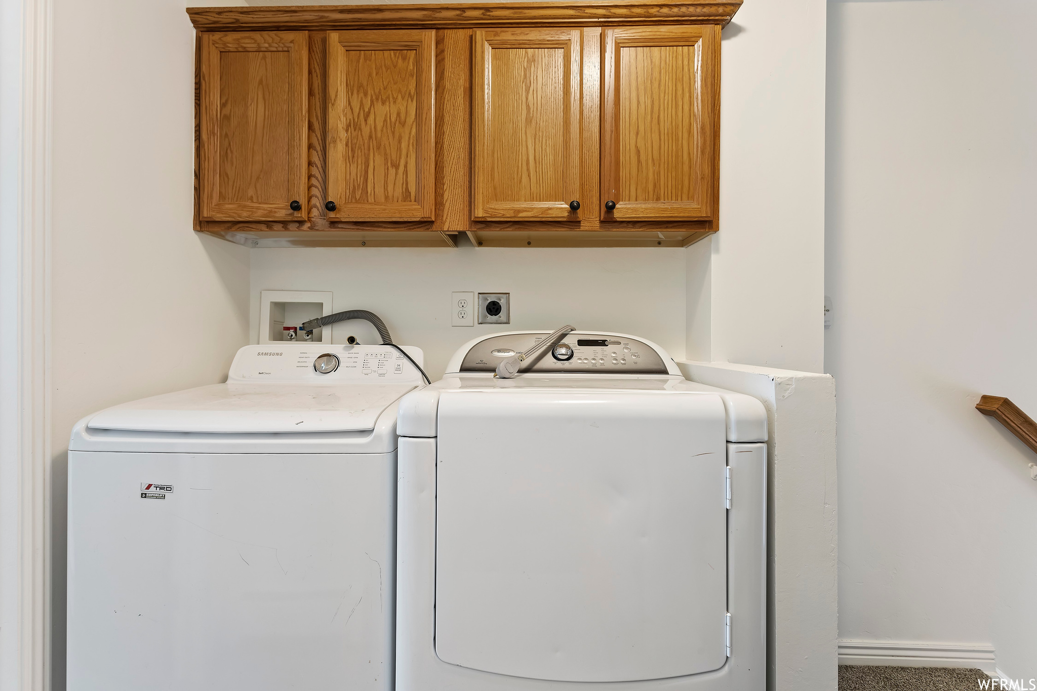 Laundry area featuring cabinets, washing machine and dryer, hookup for an electric dryer, and washer hookup
