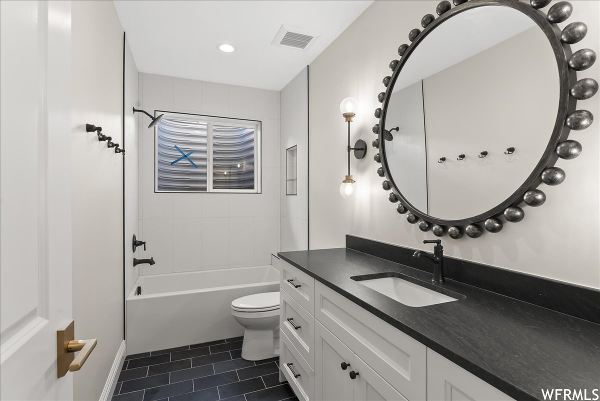 Full bathroom with toilet, tile floors,  shower combination, and vanity