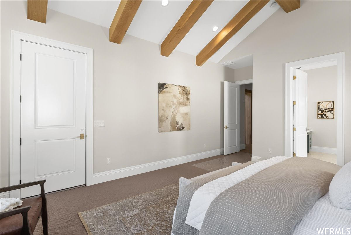 Bedroom featuring vaulted ceiling with beams and carpet flooring