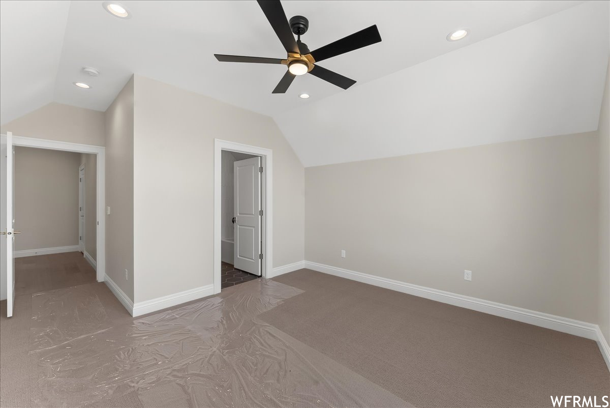 Bonus room featuring ceiling fan, vaulted ceiling, and light colored carpet