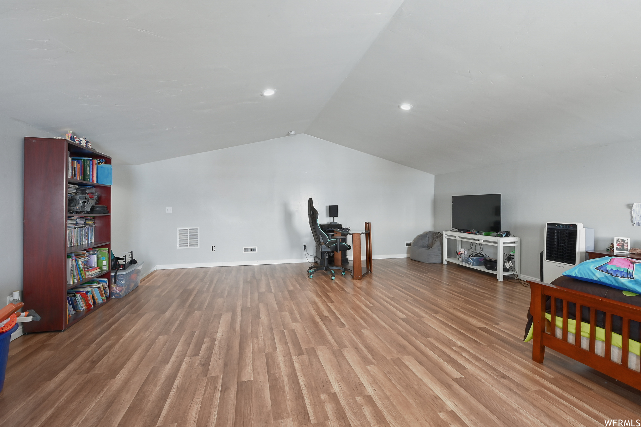 Bedroom with lofted ceiling and hardwood / wood-style flooring