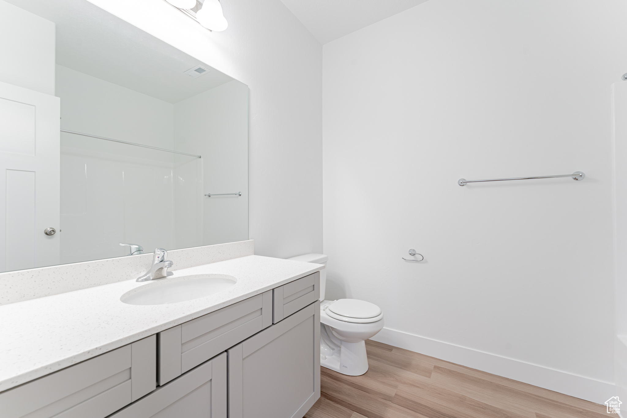 Bathroom featuring oversized vanity, wood-type flooring, and toilet