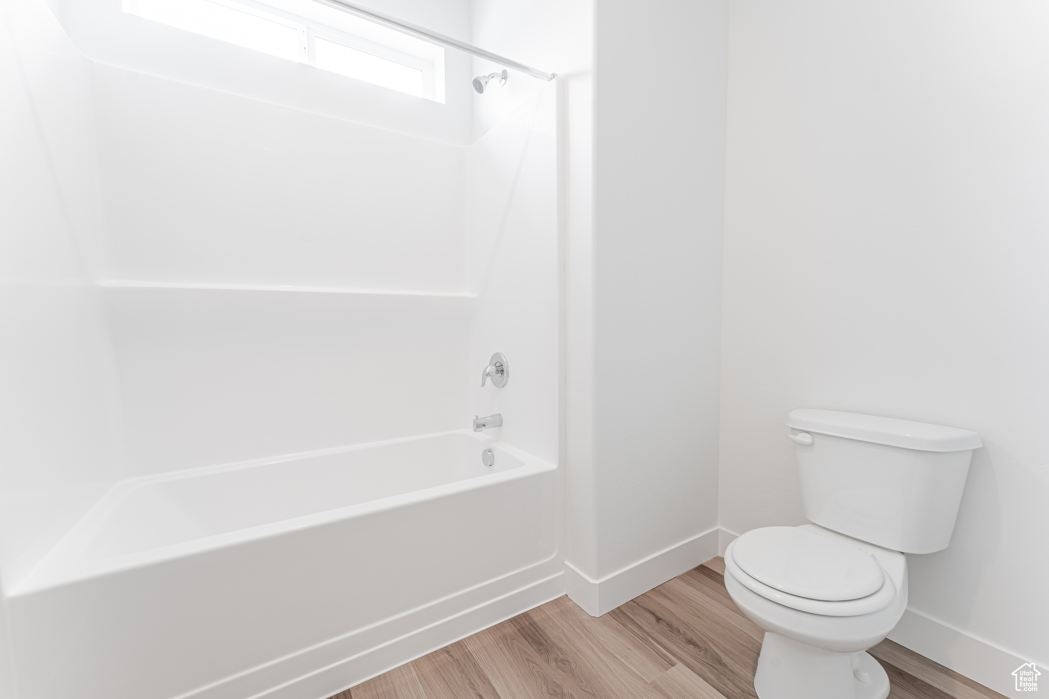 Bathroom featuring shower / bathing tub combination, toilet, and hardwood / wood-style flooring