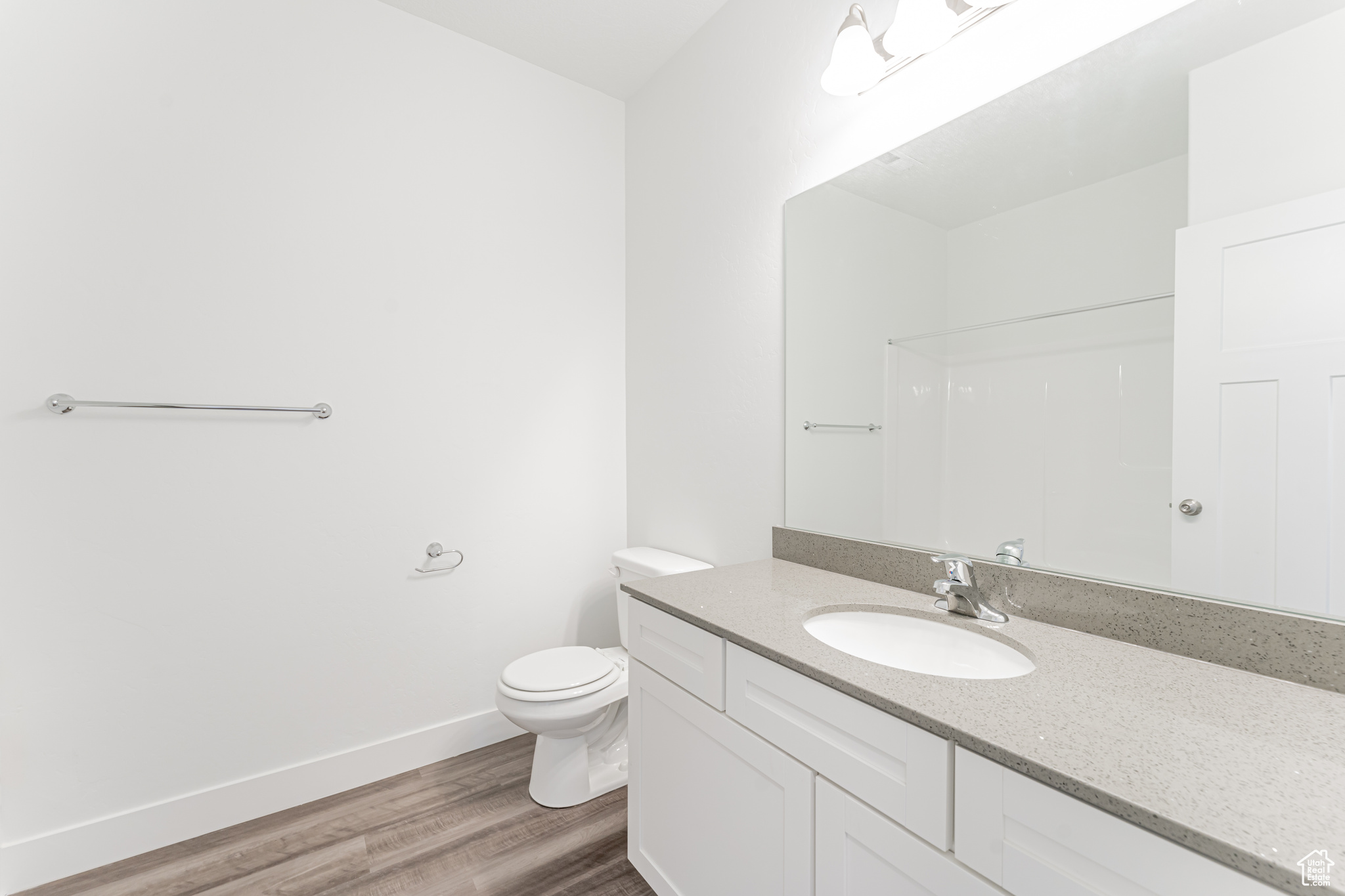 Bathroom with toilet, hardwood / wood-style floors, and vanity
