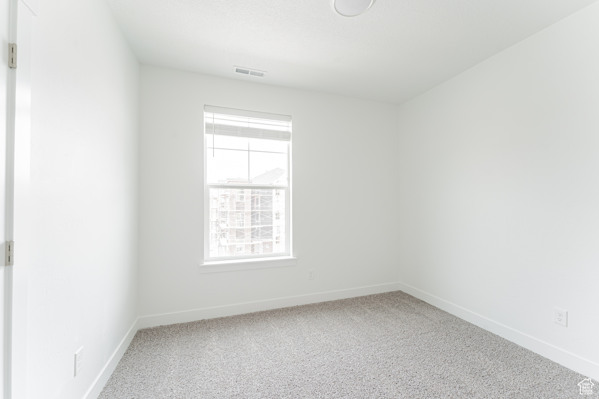 Empty room with plenty of natural light and light carpet