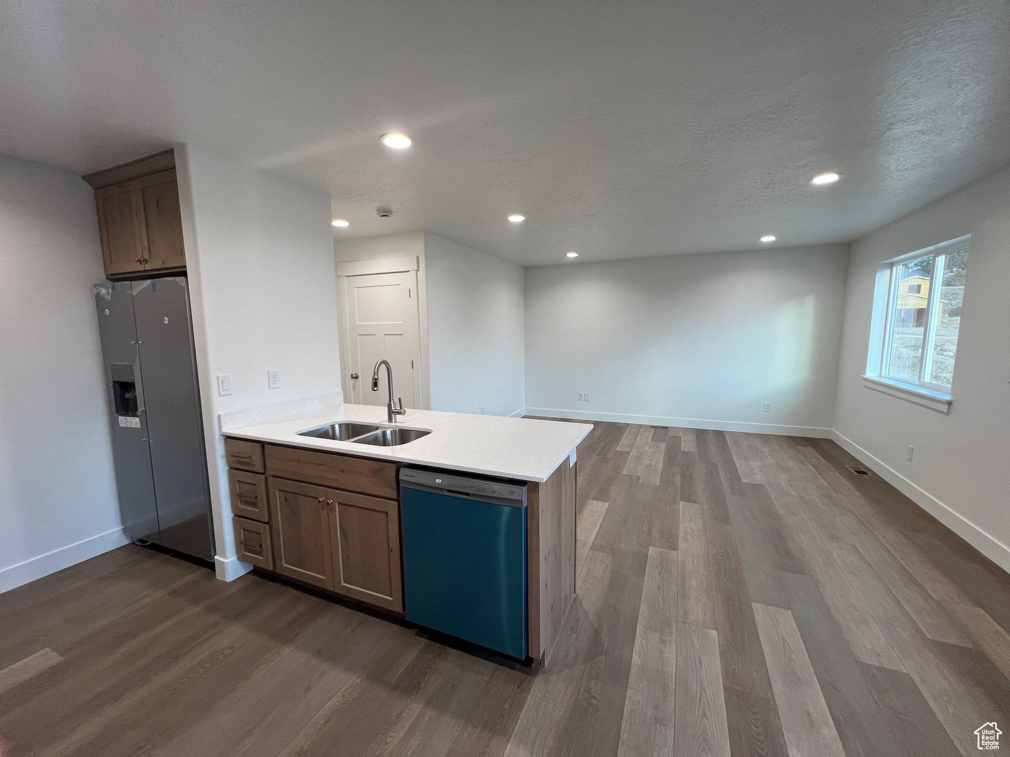 Kitchen with dishwashing machine, light hardwood / wood-style floors, refrigerator, and sink