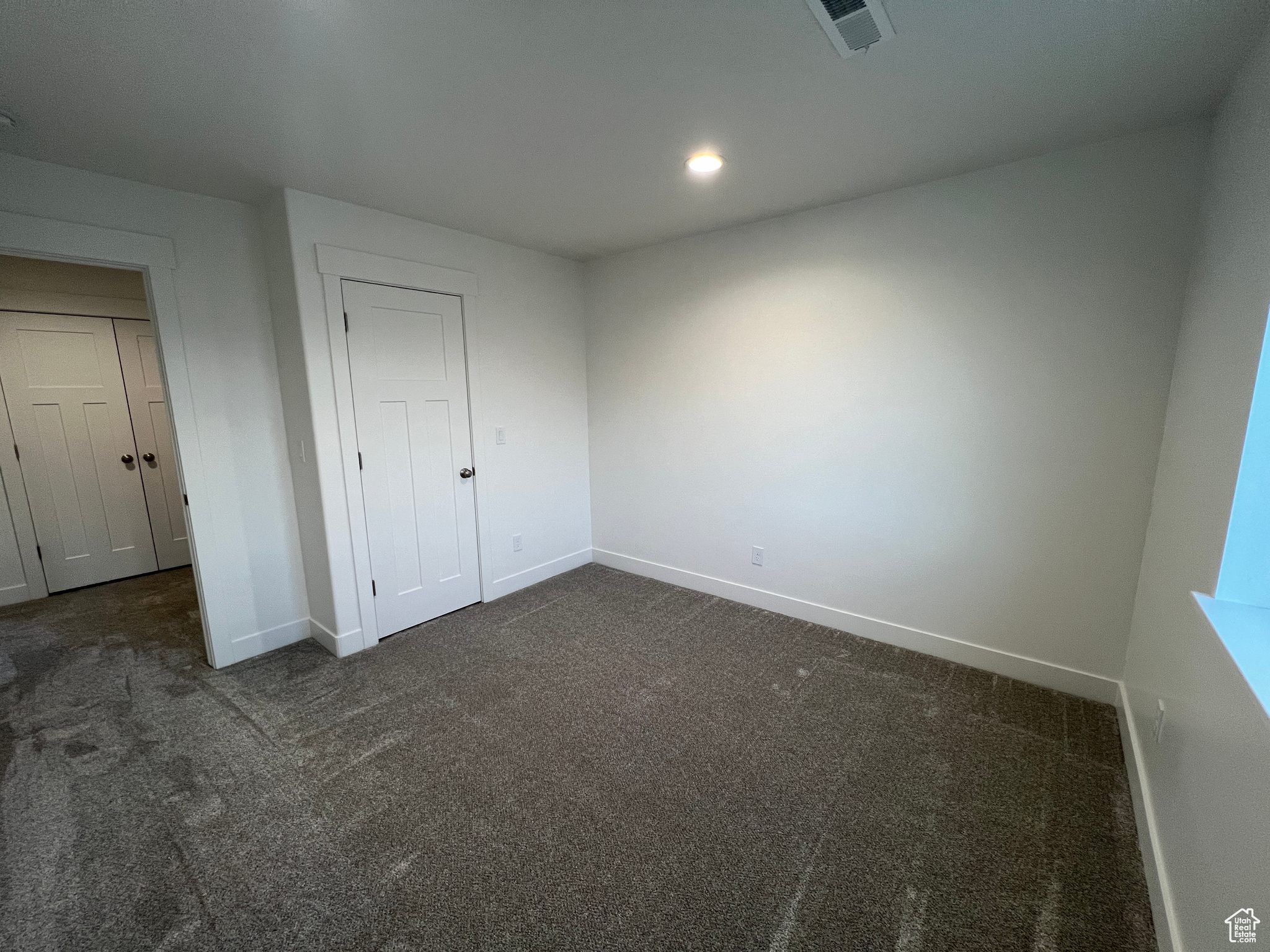 Unfurnished Guest bedroom 2 with dark colored carpet and a closet