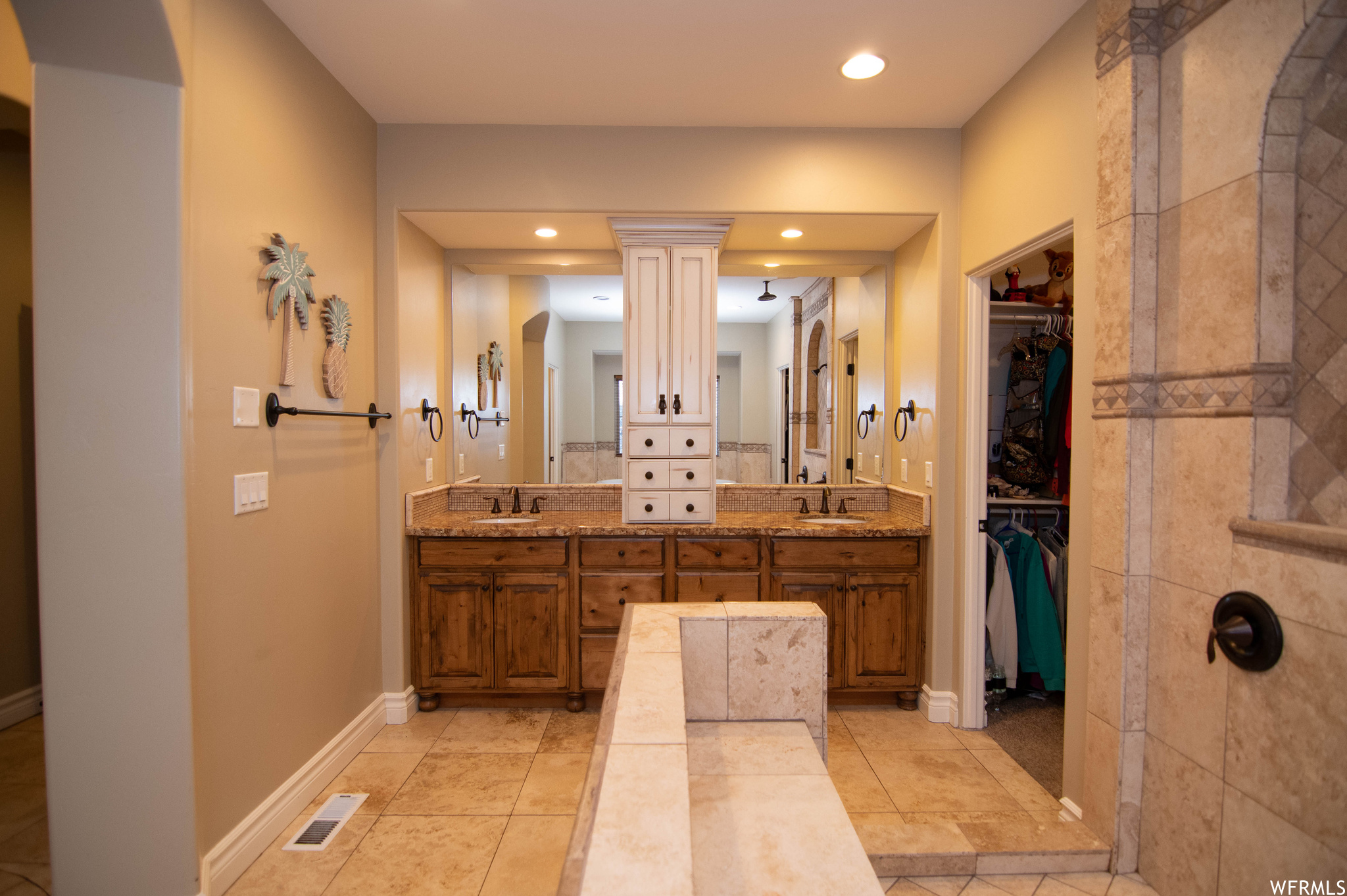 Bathroom with dual vanity, ornate columns, and tile flooring