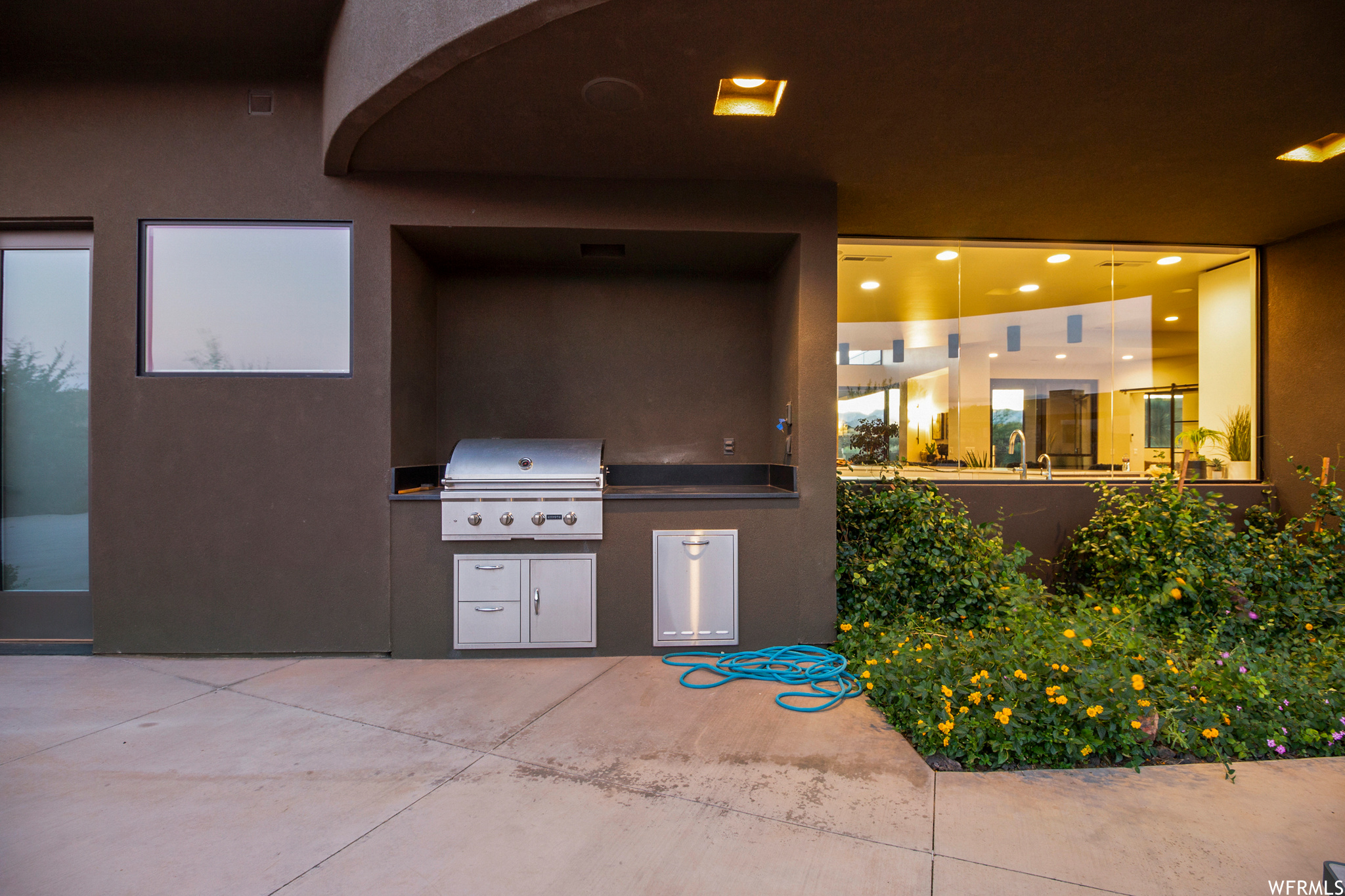View of patio with an outdoor kitchen and a grill