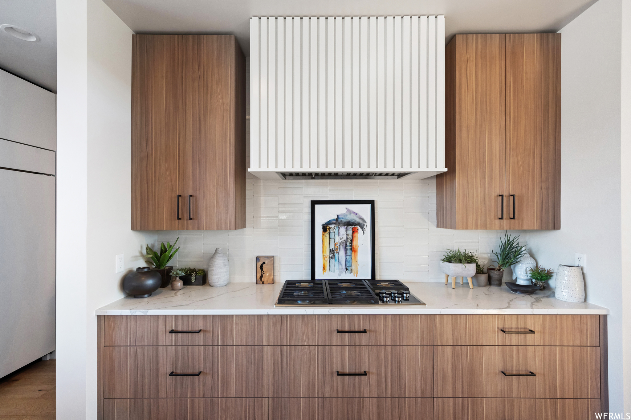 Kitchen featuring gas stovetop, backsplash, radiator, and hardwood / wood-style flooring