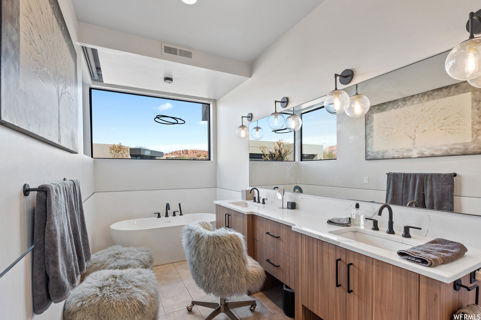 Bathroom featuring tile floors, dual vanity, and a bath to relax in