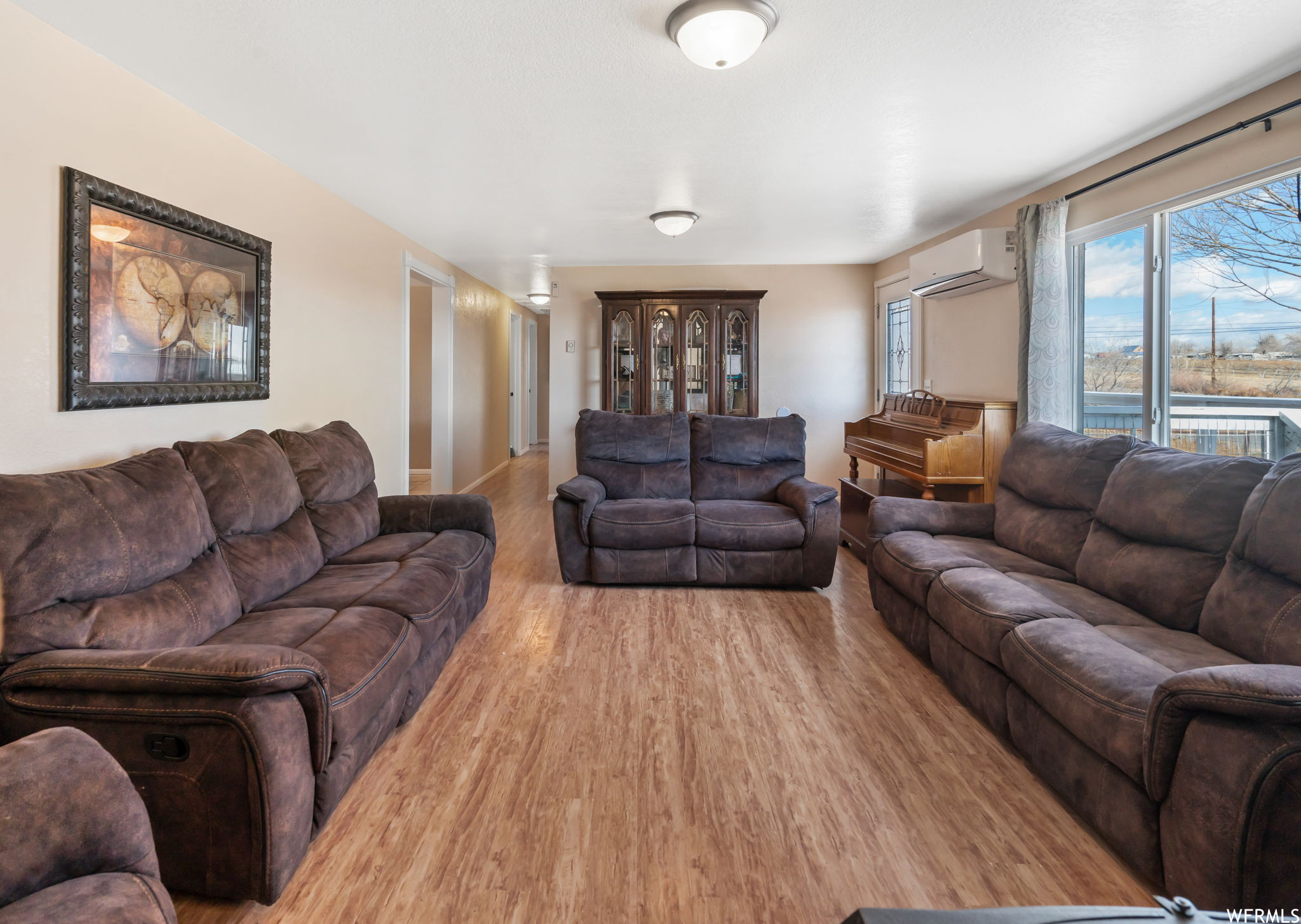 Living room featuring light hardwood / wood-style flooring and a wall unit AC