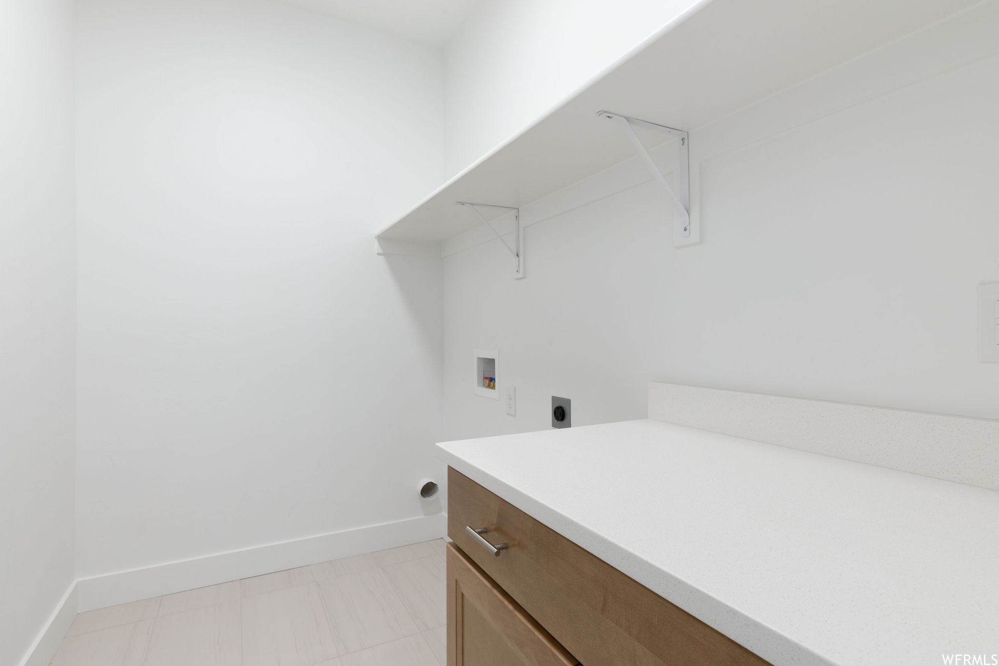 Washroom with light tile floors, hookup for an electric dryer, and washer hookup
