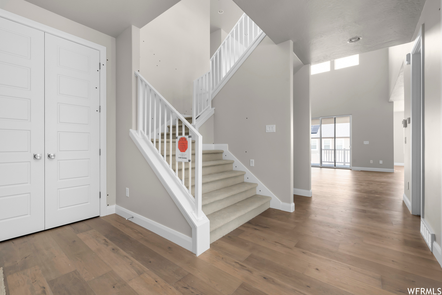 Staircase with a high ceiling and hardwood / wood-style floors