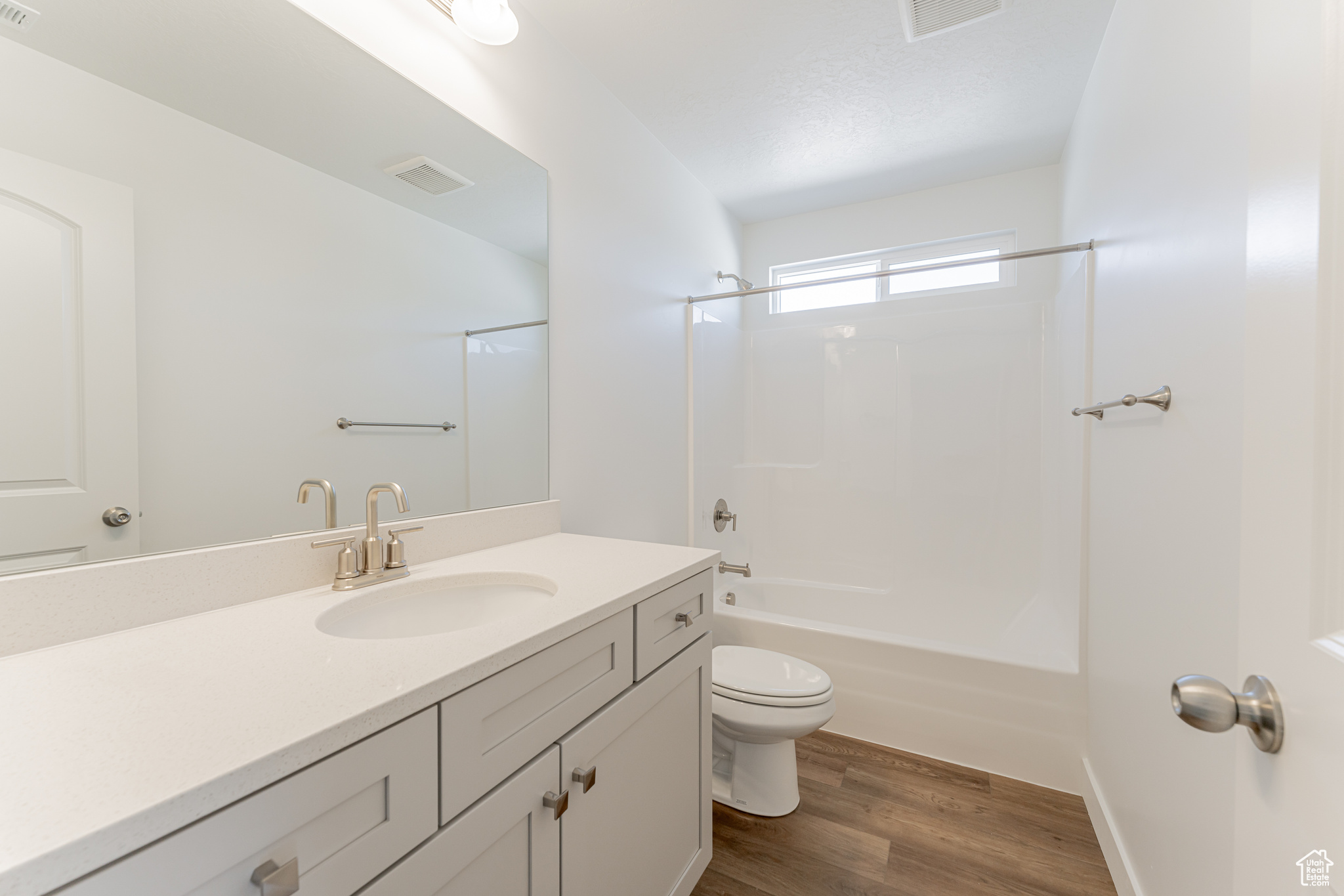 Full bathroom featuring washtub / shower combination, vanity, hardwood / wood-style flooring, and toilet