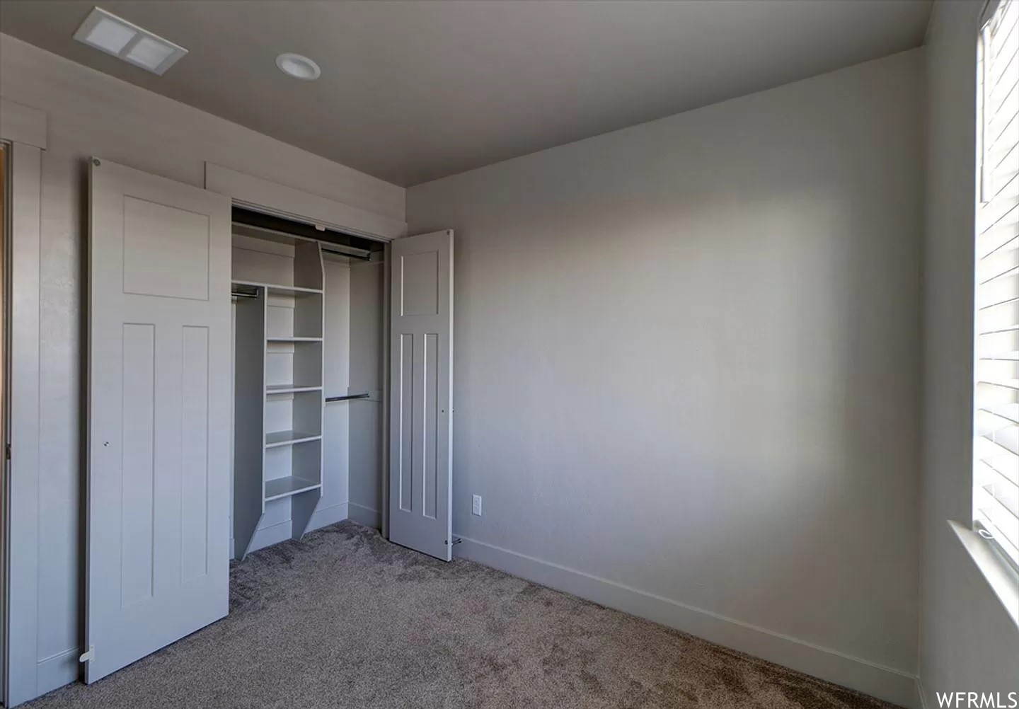 Unfurnished bedroom with multiple windows, a closet, and dark colored carpet