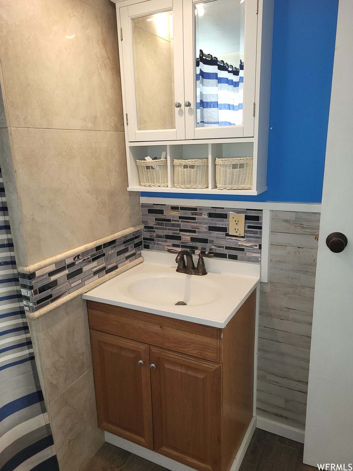 Bathroom with hardwood / wood-style flooring, large vanity, and backsplash