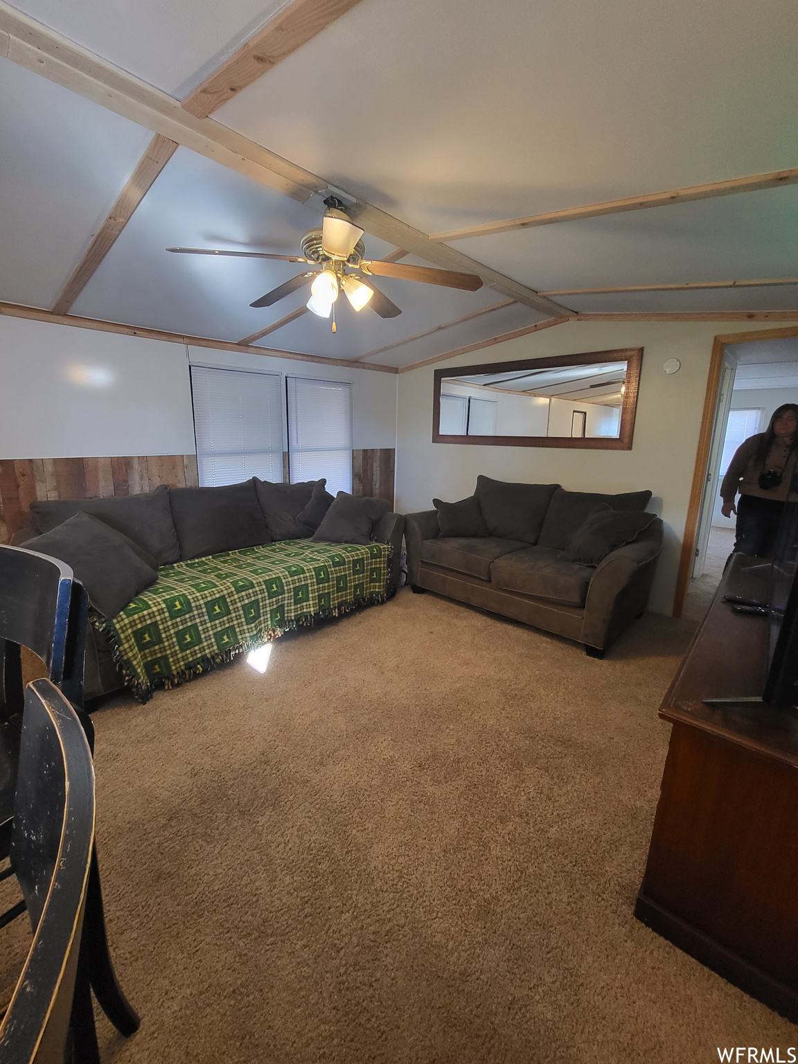 Carpeted living room with ceiling fan