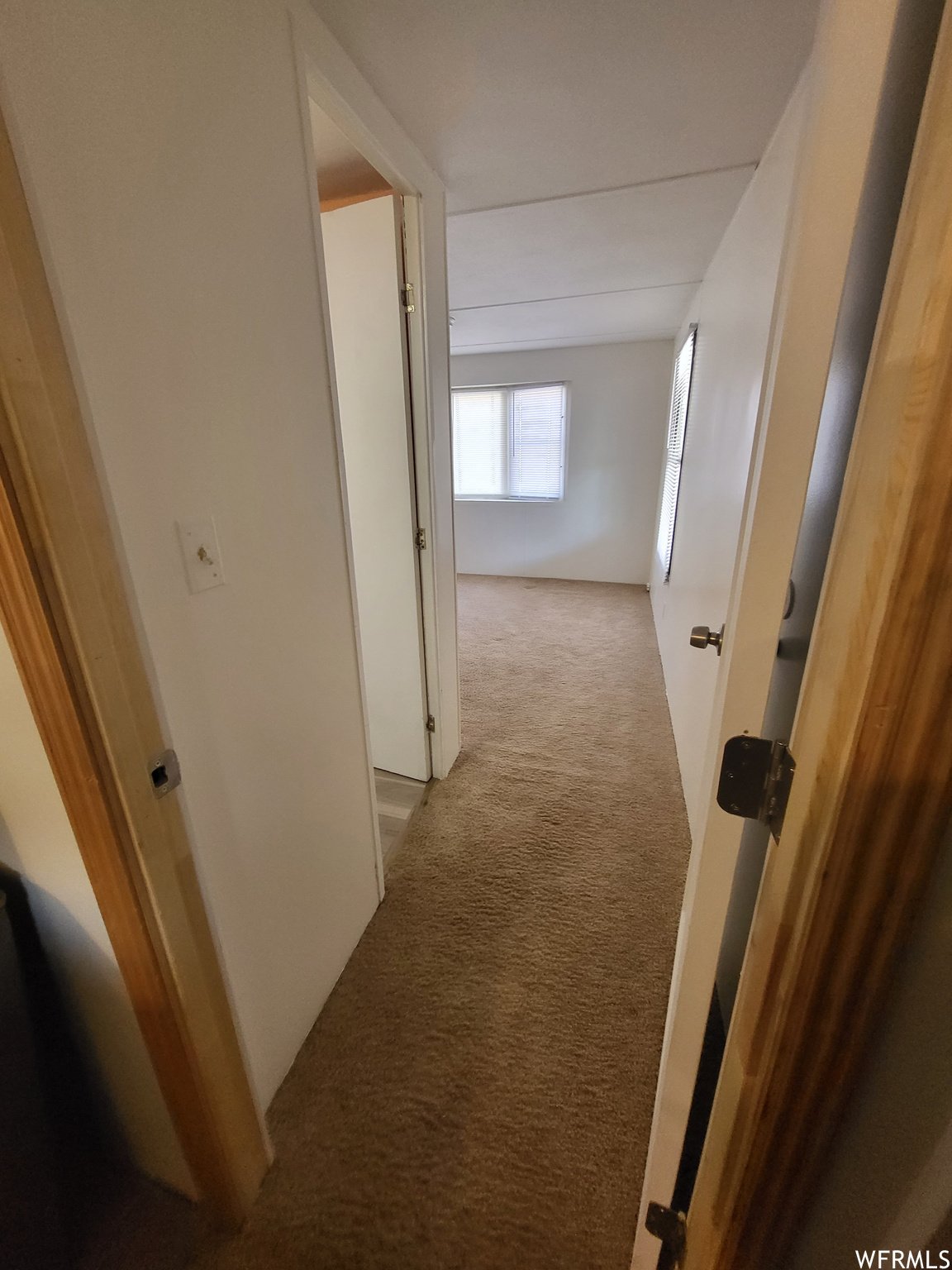 Hallway featuring light carpet