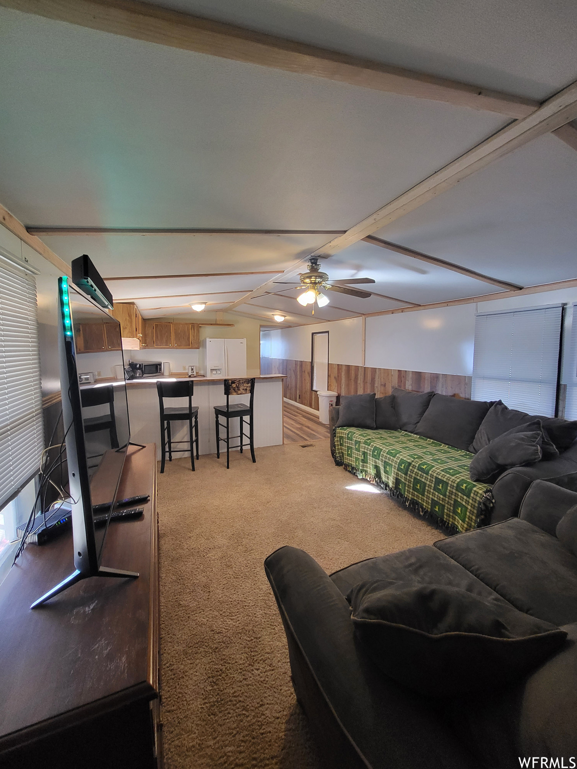 Carpeted living room with ceiling fan