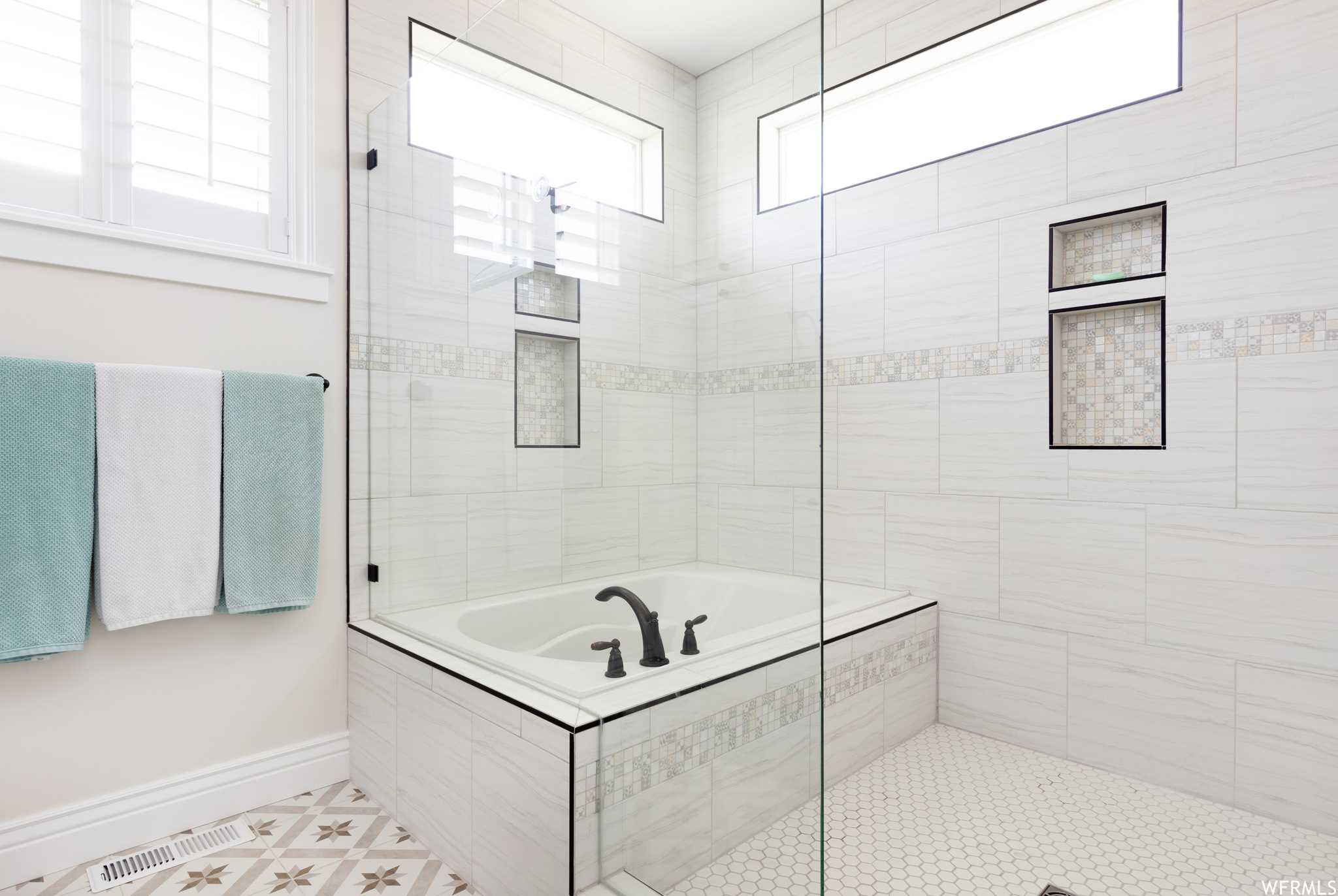 Bathroom with a healthy amount of sunlight, tile floors, and shower with separate bathtub