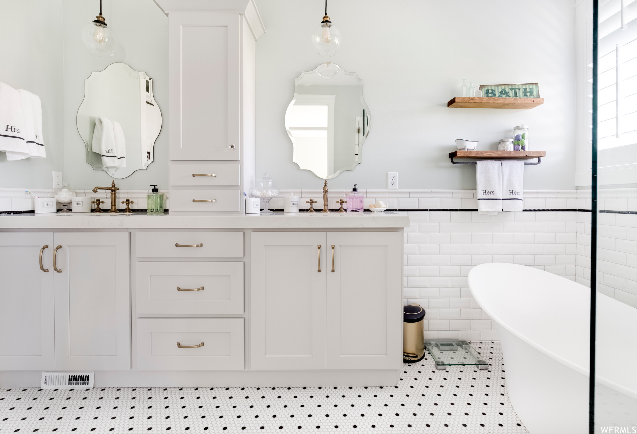Bathroom with a bathtub, tile walls, tile flooring, and dual bowl vanity