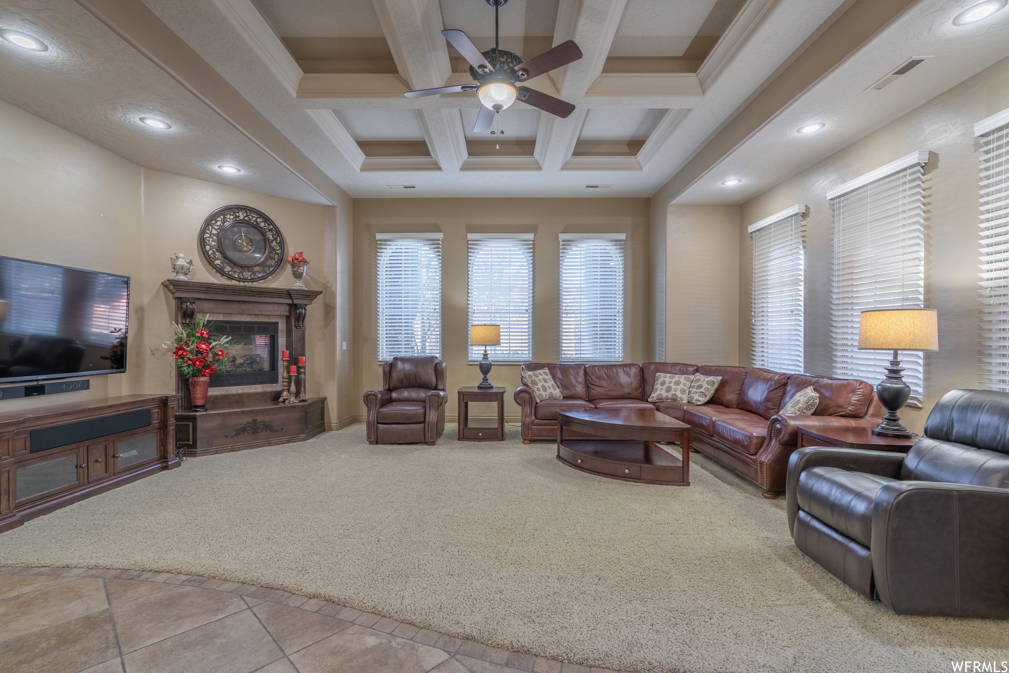 Living room featuring light colored carpet, ceiling fan, coffered ceiling, and beamed ceiling