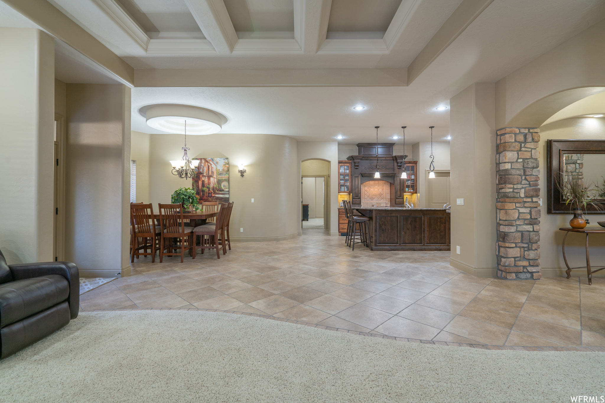 Interior space featuring a notable chandelier and beam ceiling