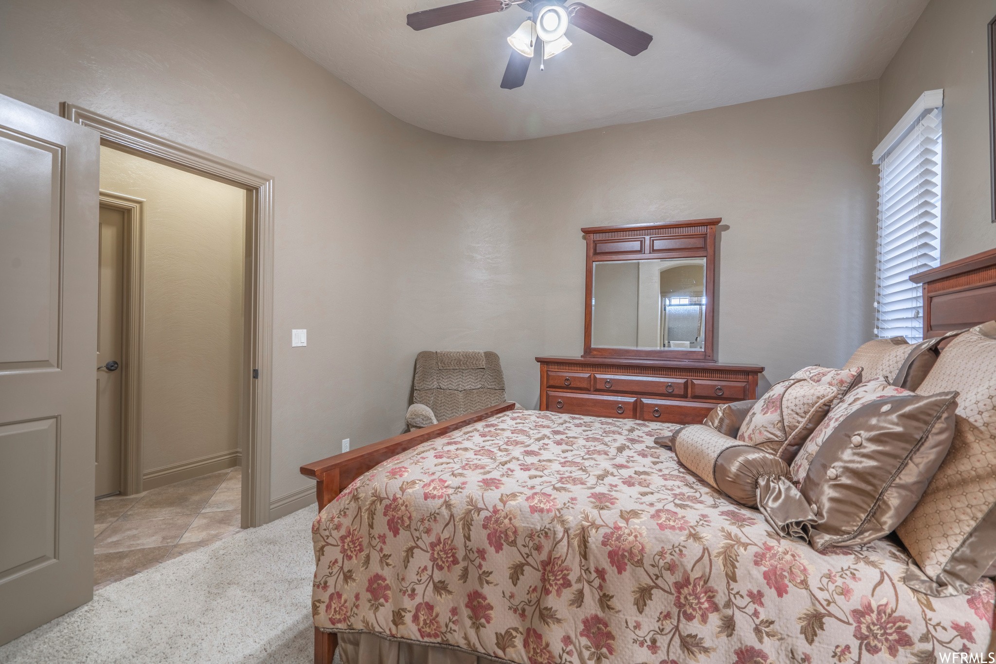 Carpeted bedroom with ceiling fan