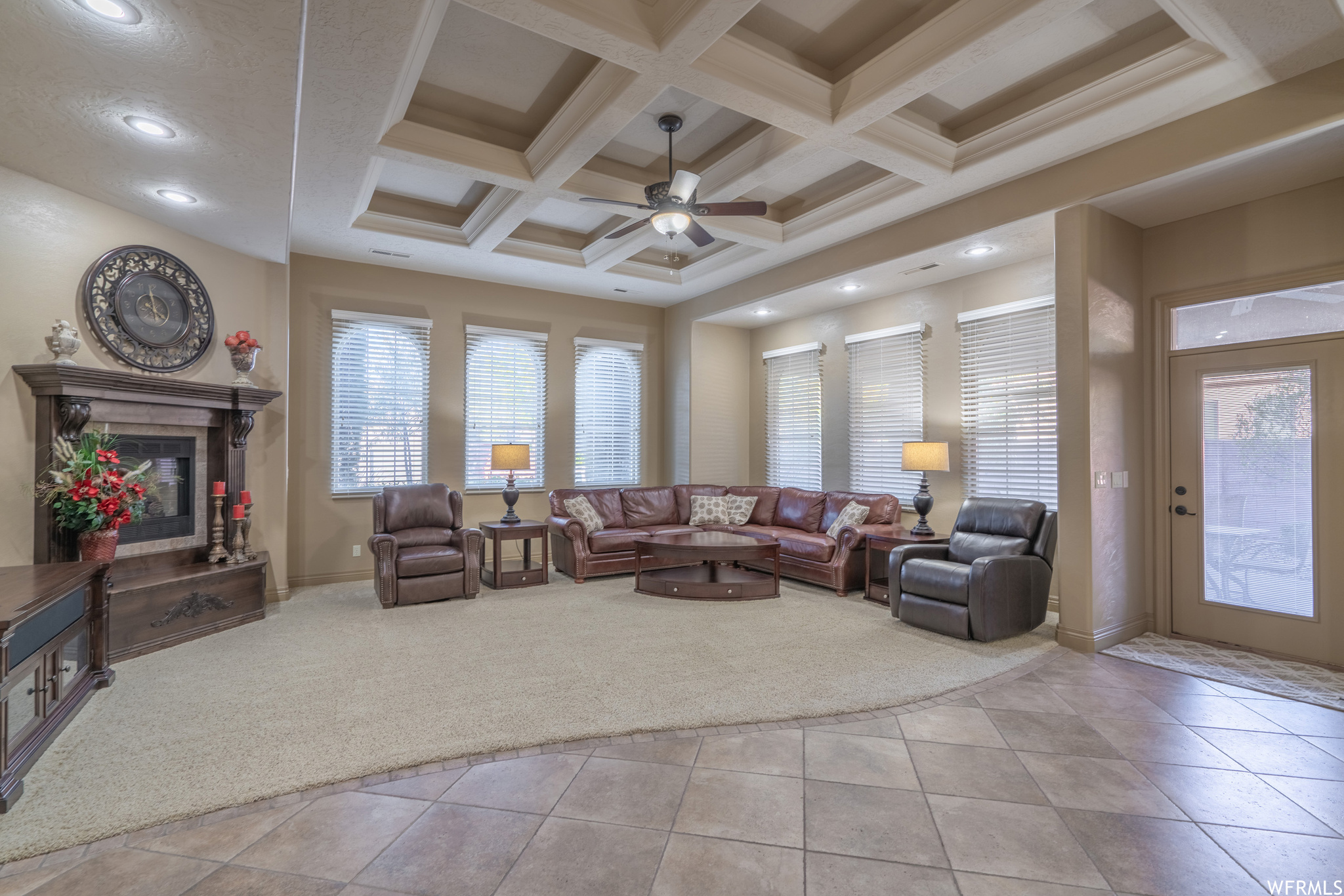 Living room with light carpet, ceiling fan, coffered ceiling, and beamed ceiling