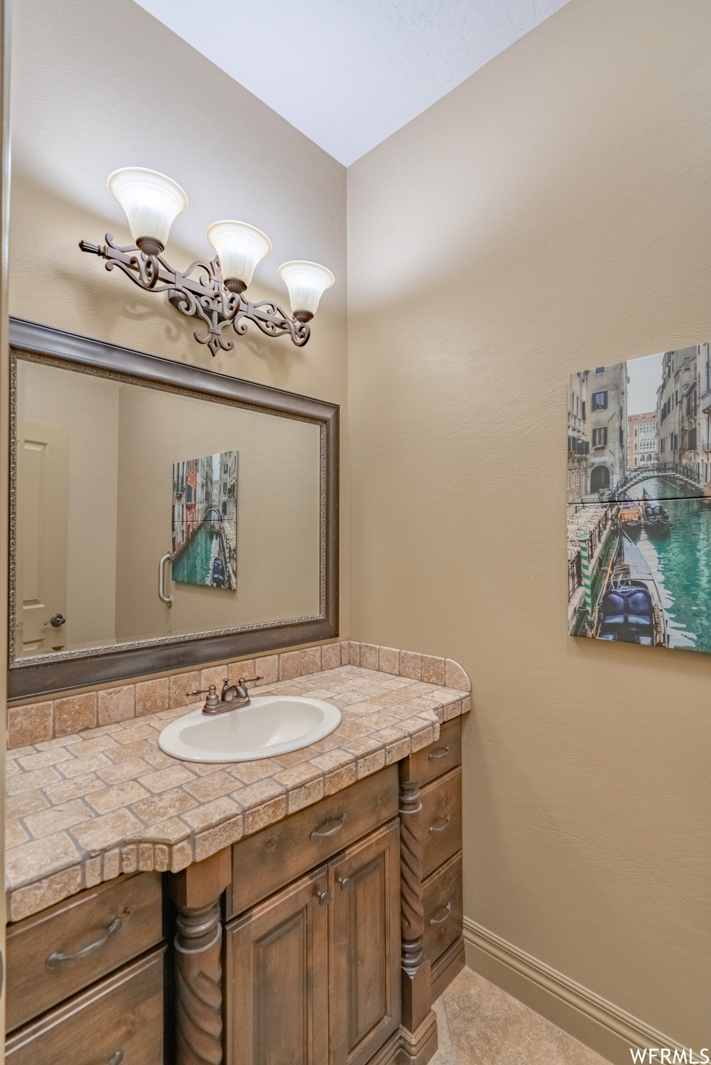 Bathroom featuring tile floors and vanity with extensive cabinet space