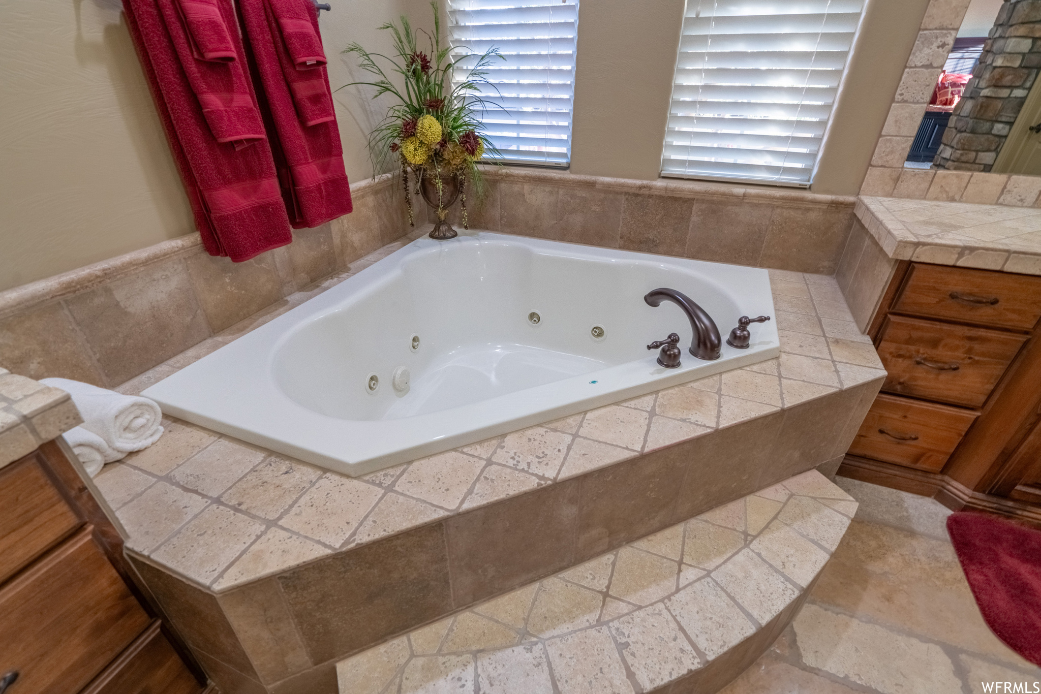 Bathroom with tile flooring and a relaxing tiled jetted tub