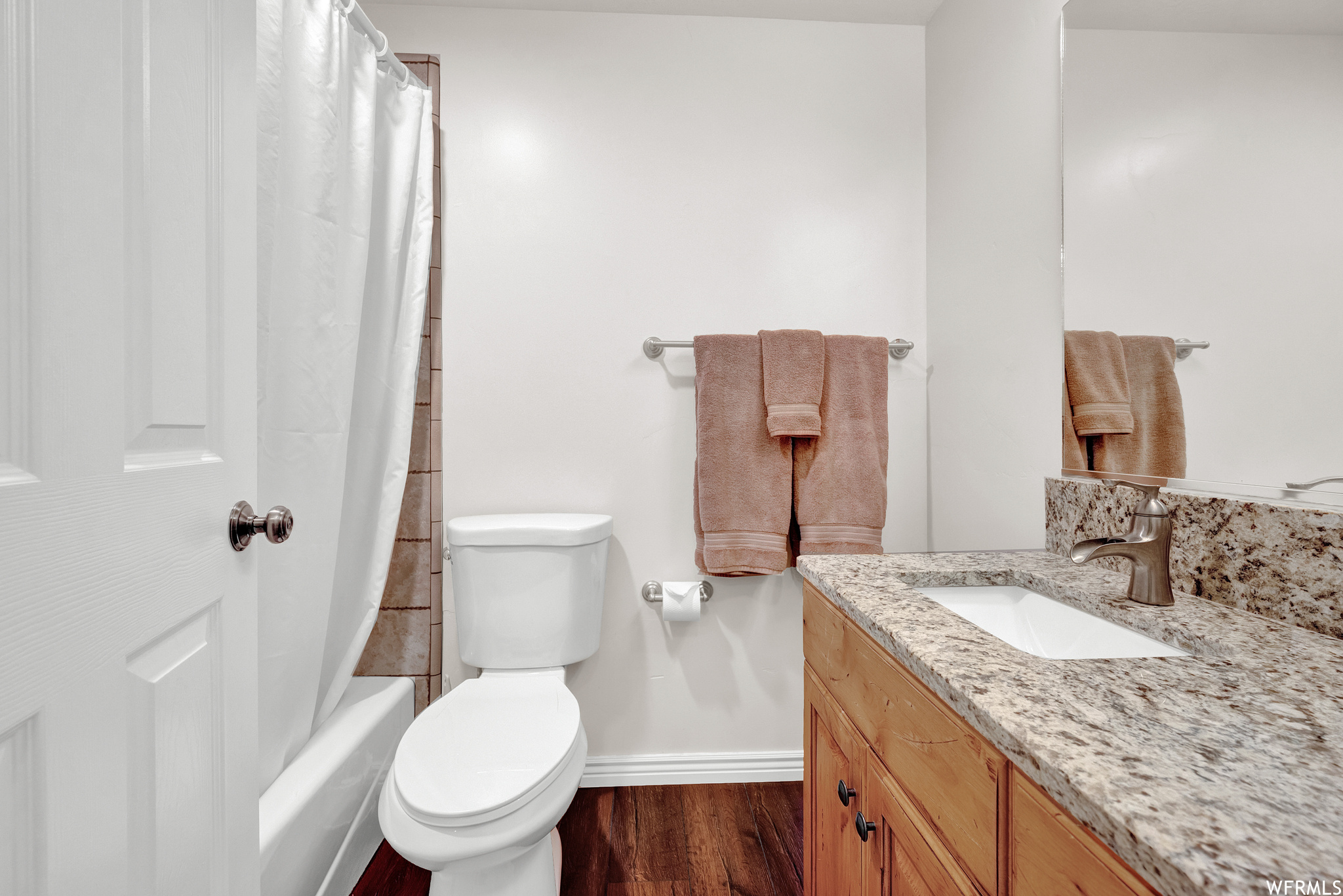 Level 2 Bathroom: Full bathroom featuring hardwood floors, shower curtain, vanity with extensive cabinet space, bathtub / shower combination, mirror, and toilet