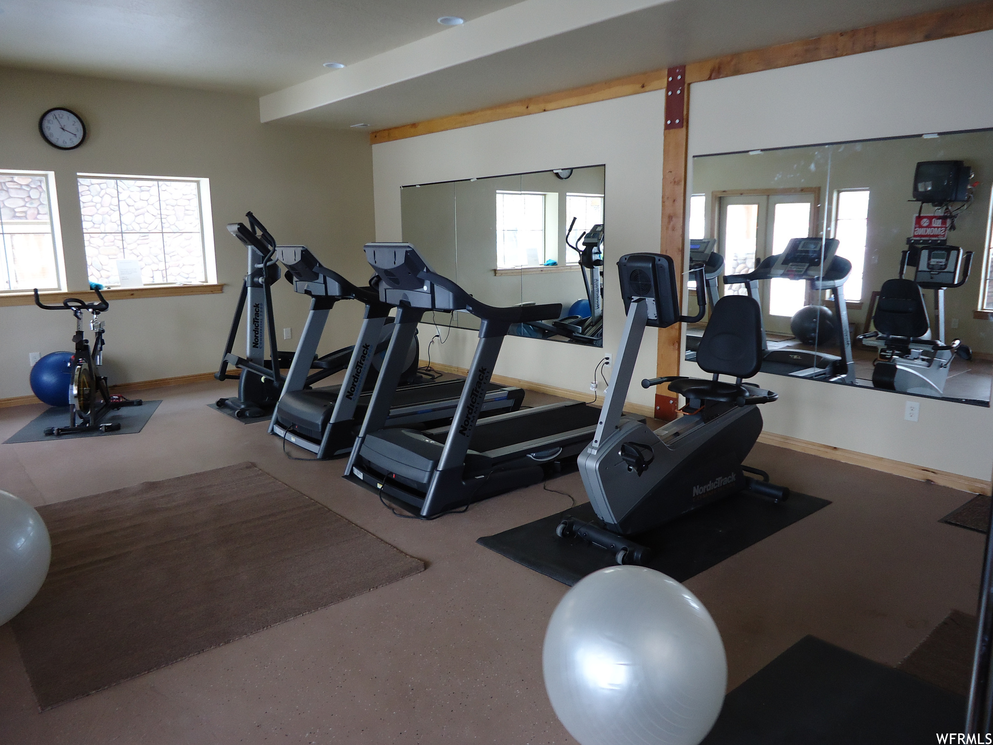 Community Gym: Workout area featuring a healthy amount of sunlight, wood beam ceiling, and TV