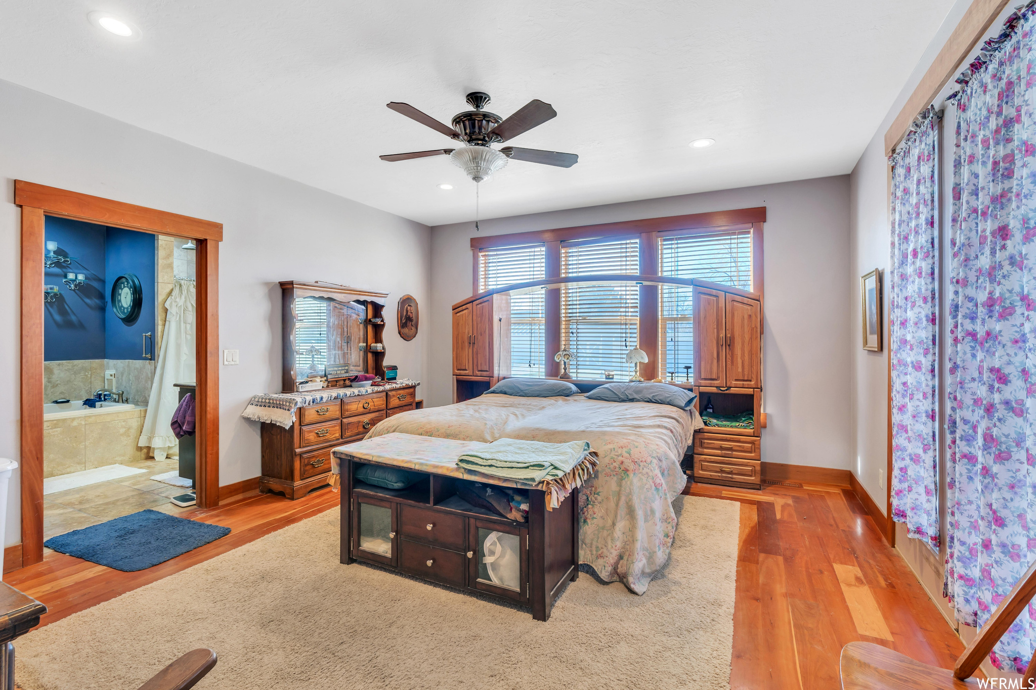 Bedroom with connected bathroom, ceiling fan, and light hardwood / wood-style flooring