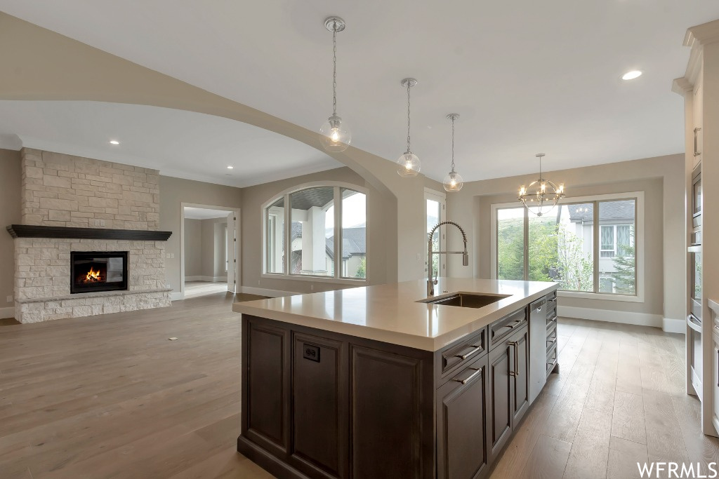 Kitchen with sink, light wood-type flooring, decorative light fixtures, and a chandelier