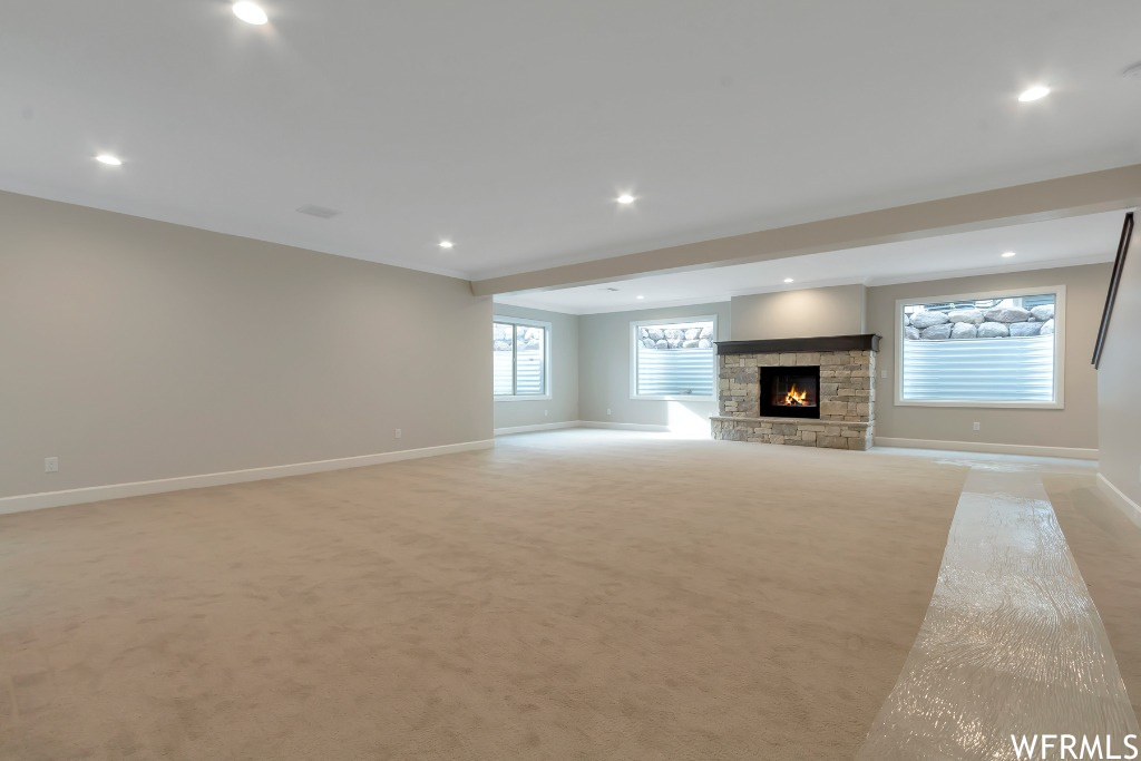 Unfurnished living room with a fireplace and light carpet