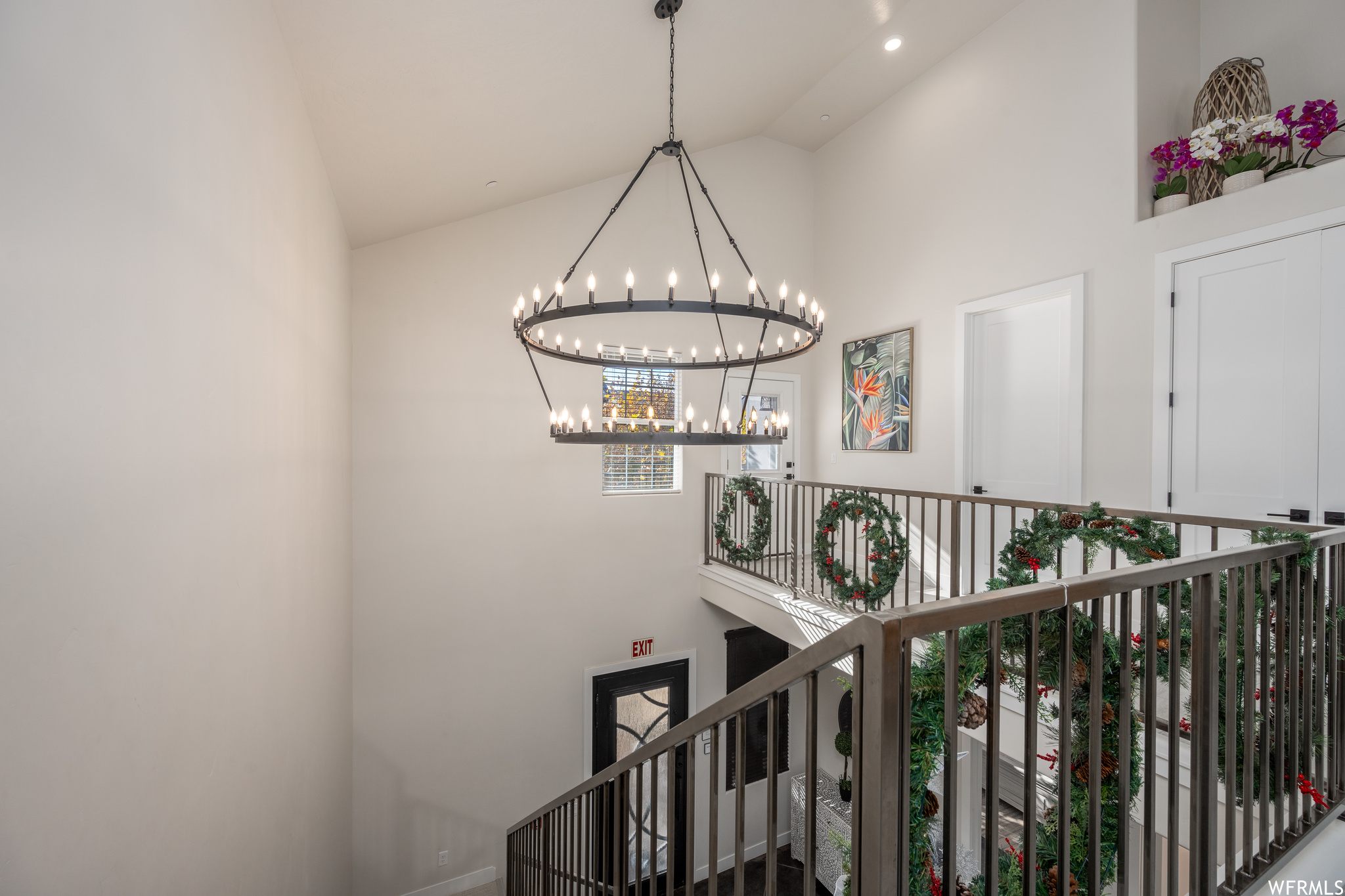 Stairs featuring a notable chandelier and high vaulted ceiling