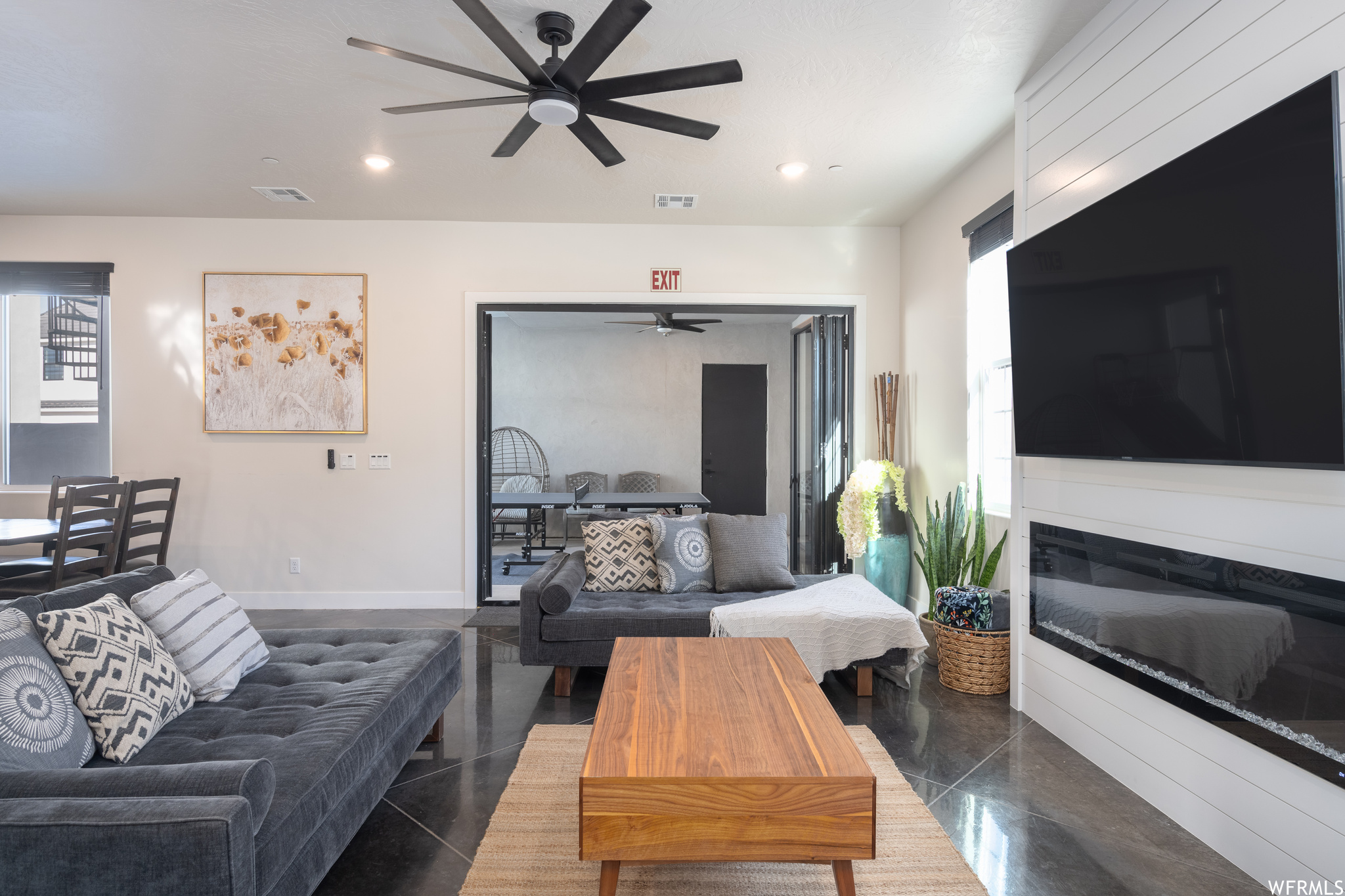 Living room with dark tile flooring and ceiling fan