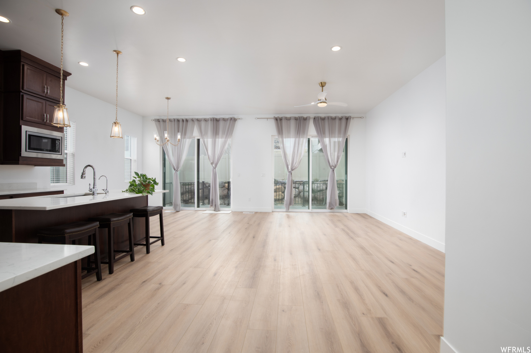 Interior space with light hardwood / wood-style flooring, ceiling fan, and sink