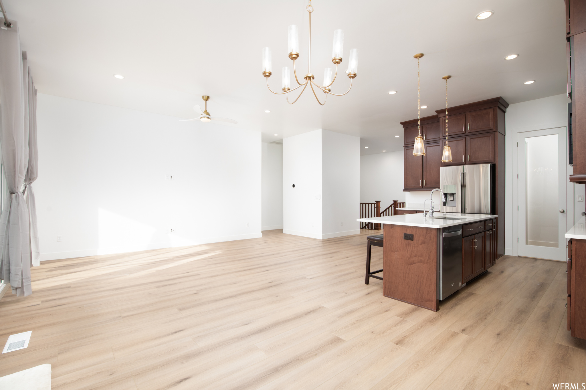Kitchen featuring a center island with sink, a breakfast bar, pendant lighting, and light hardwood / wood-style floors