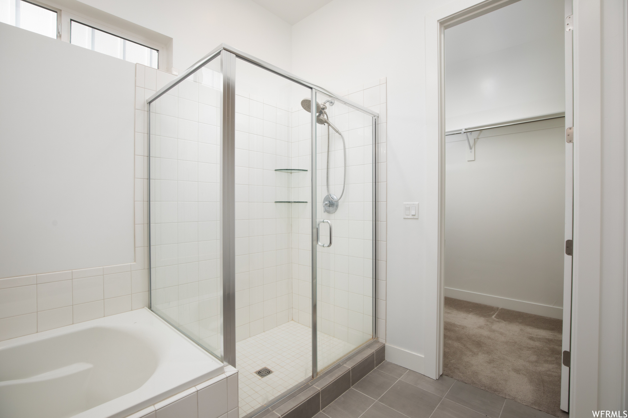 Bathroom featuring separate shower and tub and tile floors