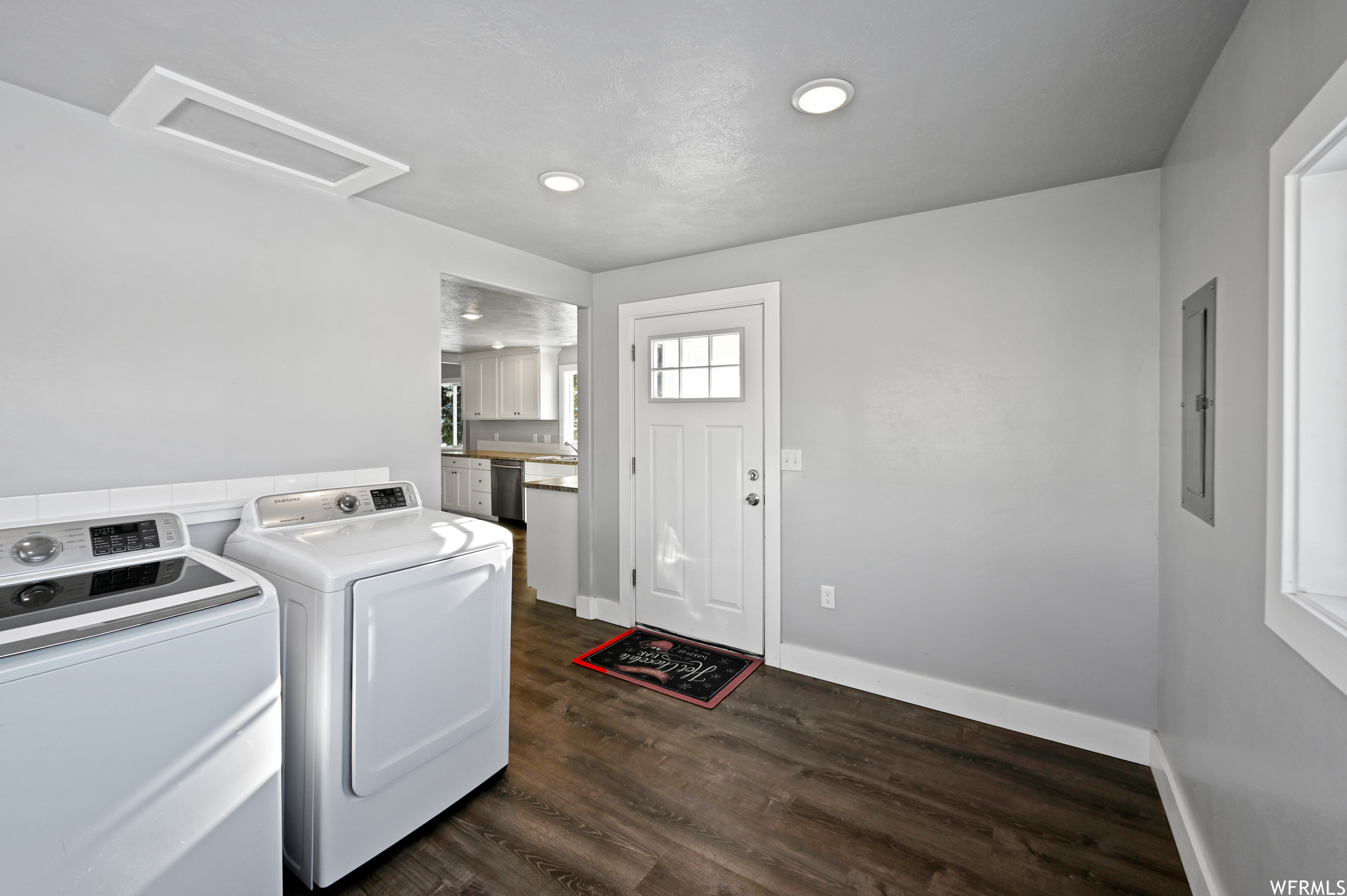 Laundry room featuring dark wood-type flooring and washing machine and clothes dryer